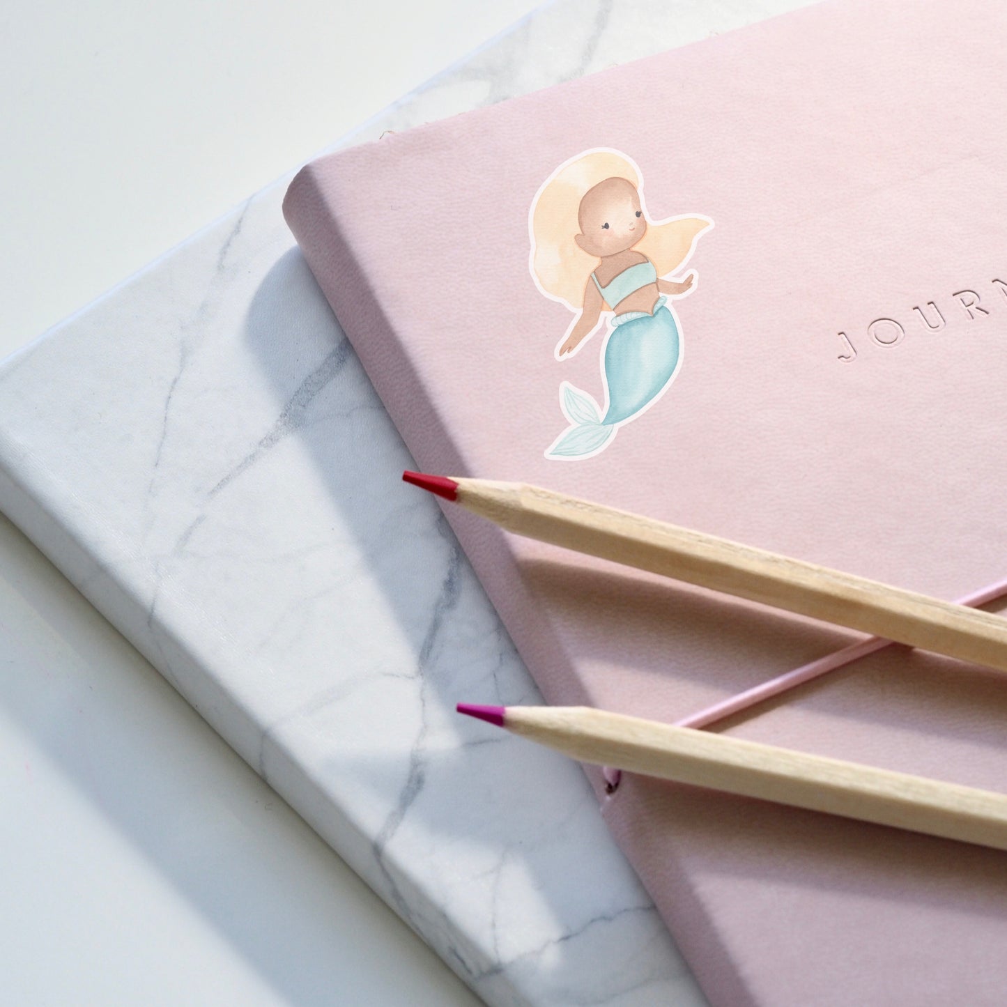 Sticker Meerjungfrau blond auf rosa Notizbuch mit Bleistiften, spritzfest und langlebig, ideal für Bullet Journals oder Bastelprojekte. Hochwertiges Vinyl, handgefertigt.