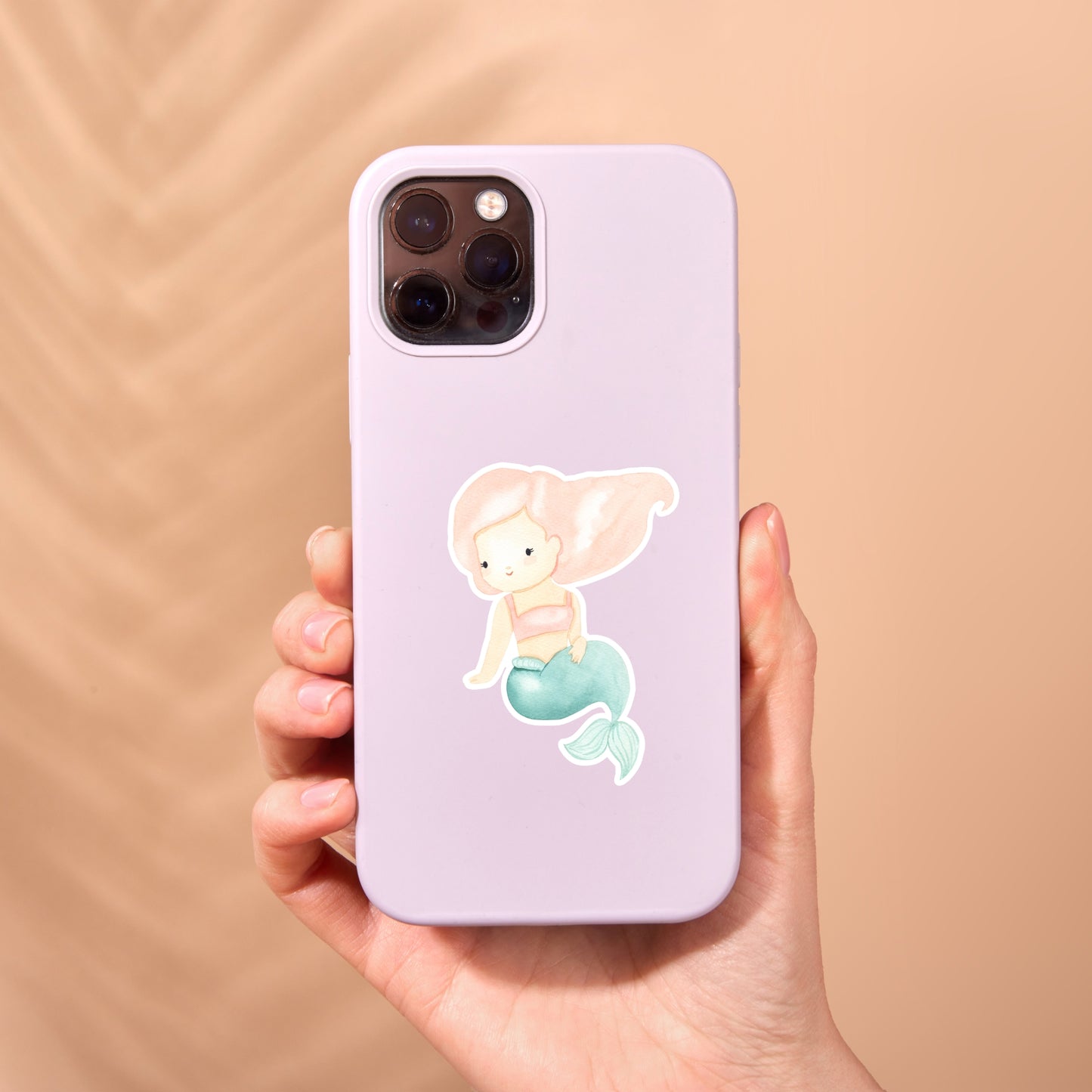 Hand hält eine Handyhülle mit dem Sticker Meerjungfrau rosa, zeigt eine cartoonhafte Meerjungfrau. Ideal für Fans, verleiht magischen Touch.
