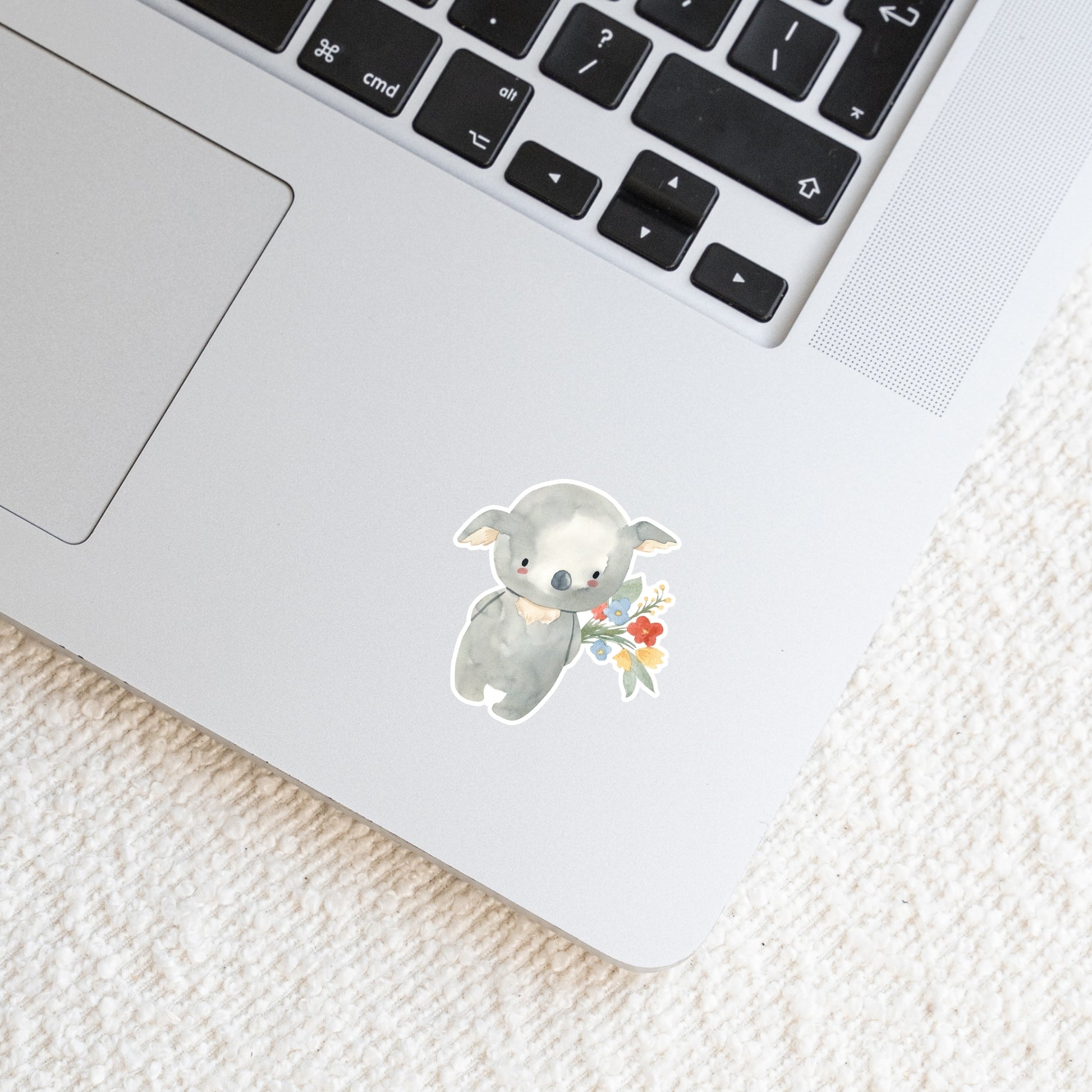 Laptop mit Sticker Koala & Blumen: Handgemalter Koala hält Blumenstrauß. Hochwertiger, spritzfester Vinyl-Sticker, ideal zur Personalisierung von Laptops oder Notizbüchern.