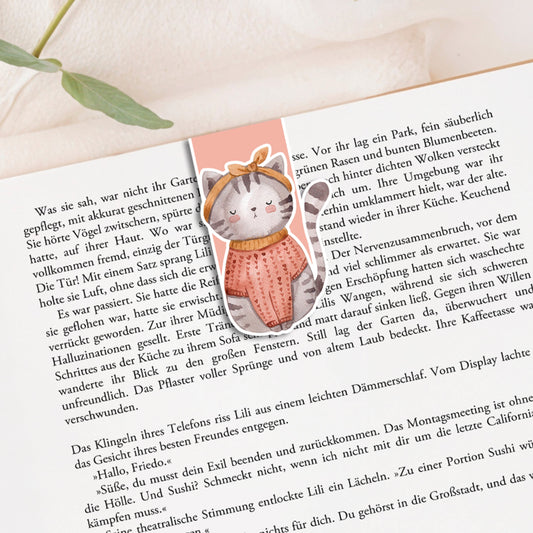 Magnetisches Lesezeichen Katze auf einem Buch; zeigt eine handgemalte Katze mit Schal und Schleife. Hergestellt aus 200g Papier, versiegelt mit Vinyl.