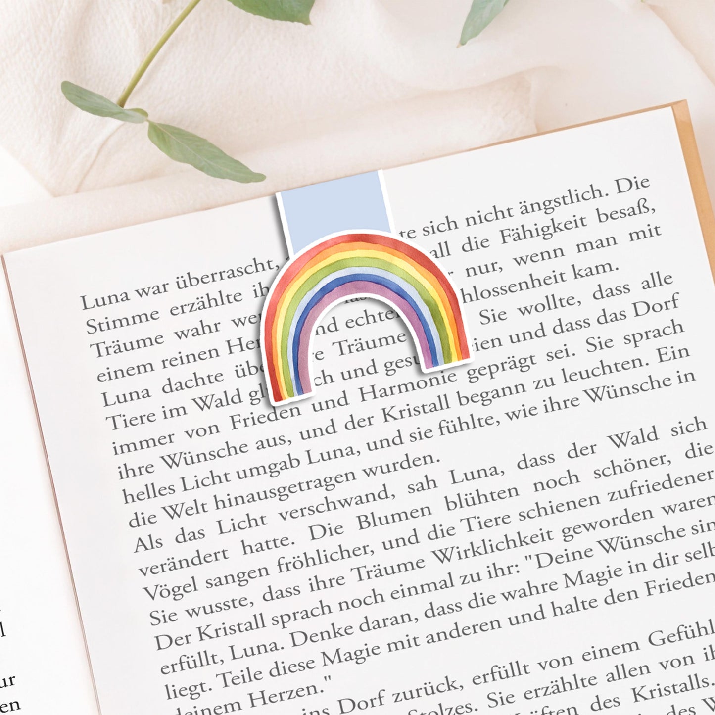 Magnetisches Lesezeichen Regenbogen blau: Handgemaltes Regenbogenmotiv auf mattem Papier, versiegelt mit Vinyl, mit Magneten zum sicheren Halt auf Buchseiten.