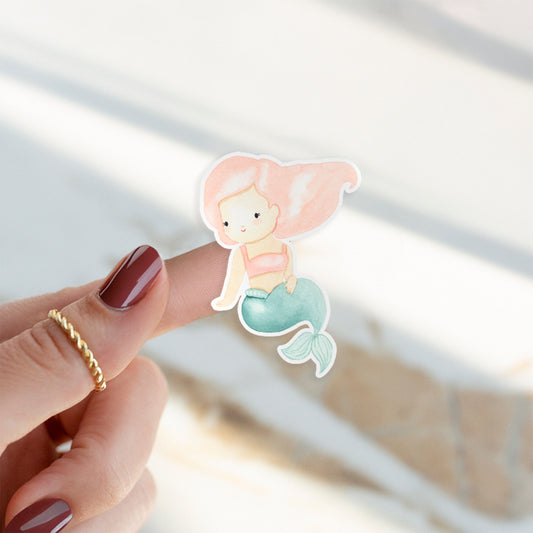 Sticker Meerjungfrau rosa auf einem Finger. Handgemalter, spritzfester Vinyl-Aufkleber in Pastelltönen, ideal für Bullet Journals, Laptops oder Handyhüllen.