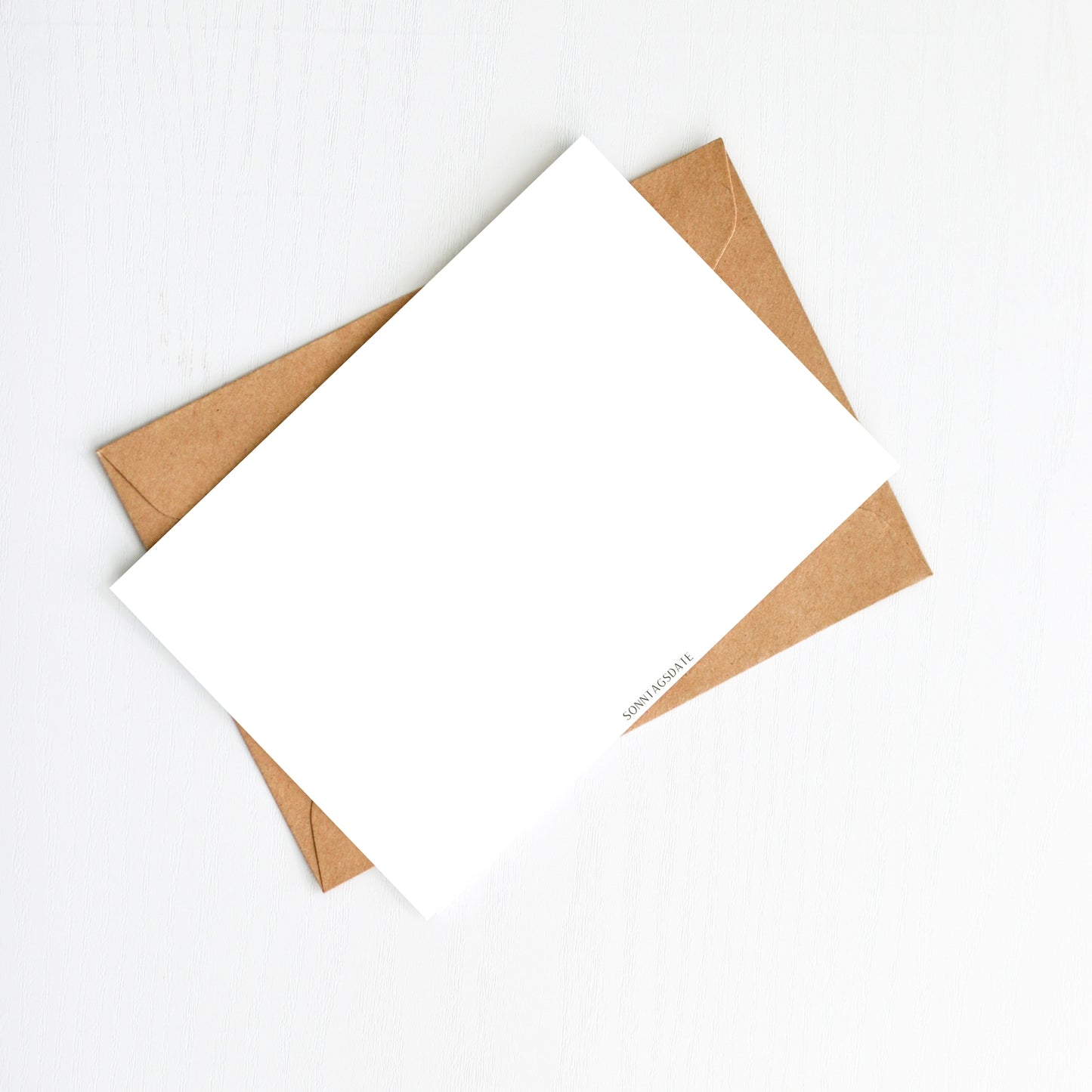 Weihnachtskarte Mäuse & Lichterkette Frohe Weihnachten A6: Weiße Karte auf Kraftpapier-Umschlag, mit „SONNTAGSDATE.“-Logo, ideal für festliche Weihnachtsgrüße oder als Dekoration.