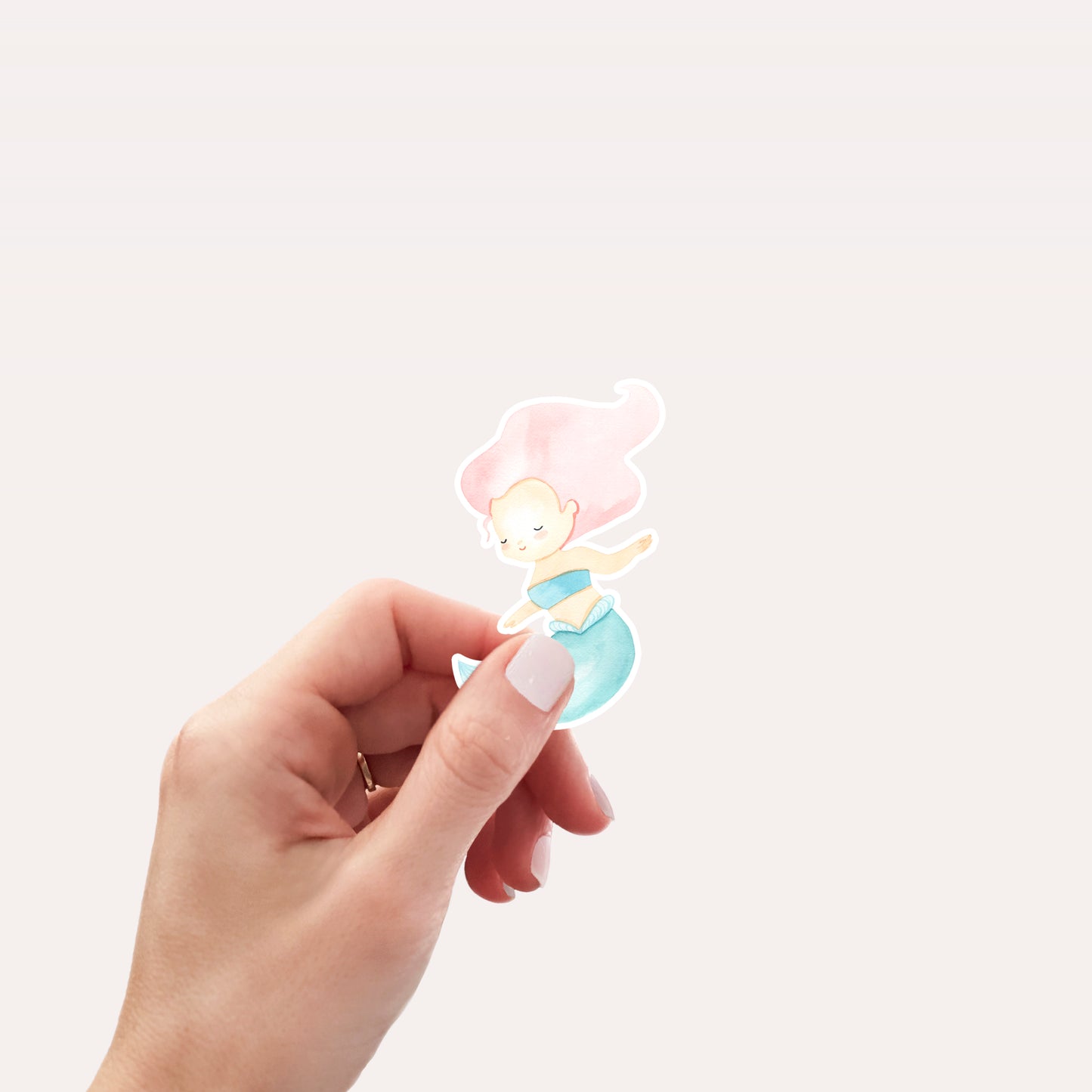 Hand hält Sticker Meerjungfrau pink, ein handgemalter Vinyl-Aufkleber in Pastelltönen, ideal für Bullet Journals oder Laptops, spritzfest und langlebig.