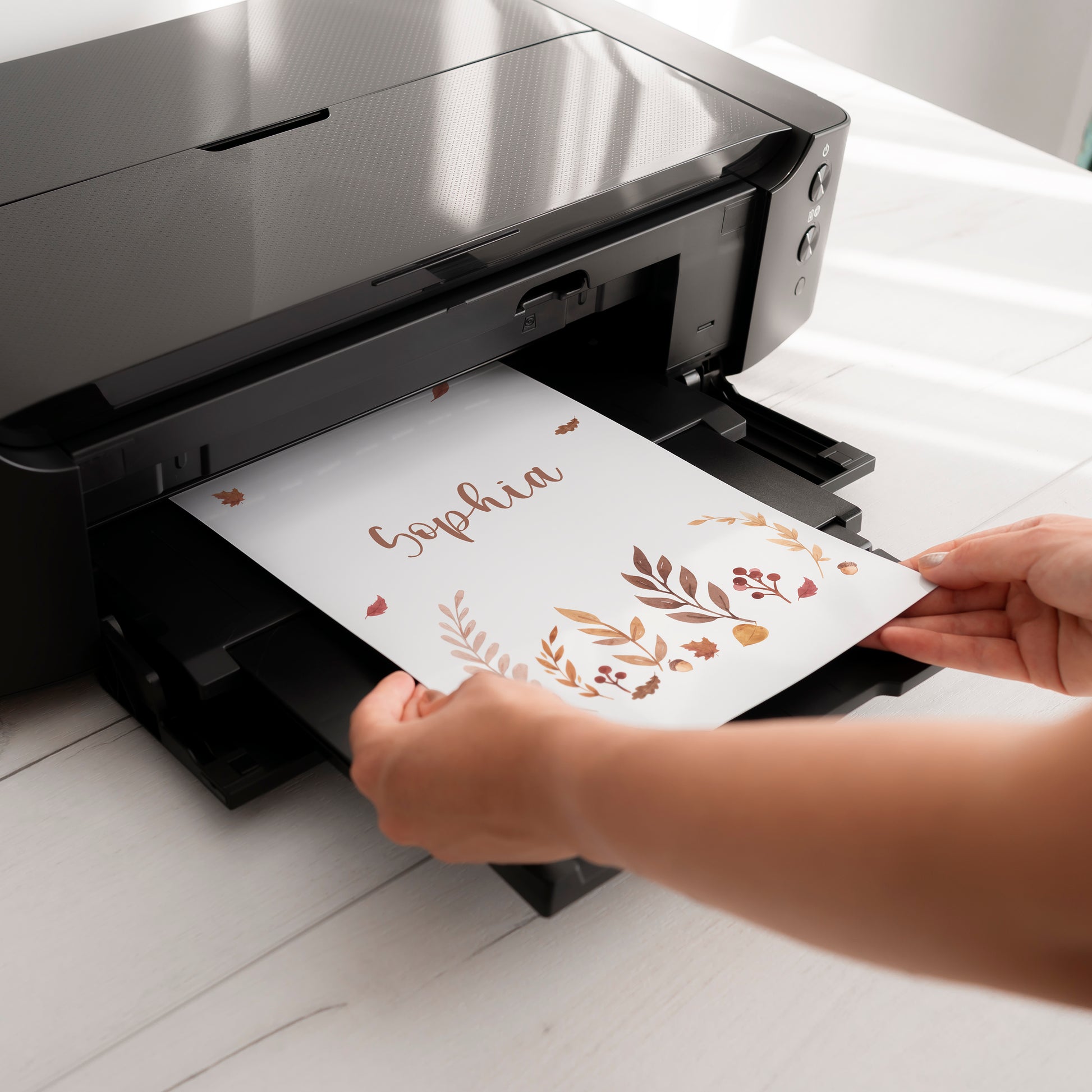 Ein schwarzer Tintenstrahldrucker druckt ein personalisiertes Namensposter Sophia mit herbstlichen Motiven, Teil des 3er Sets Waldtiere in A5, A4, A3.
