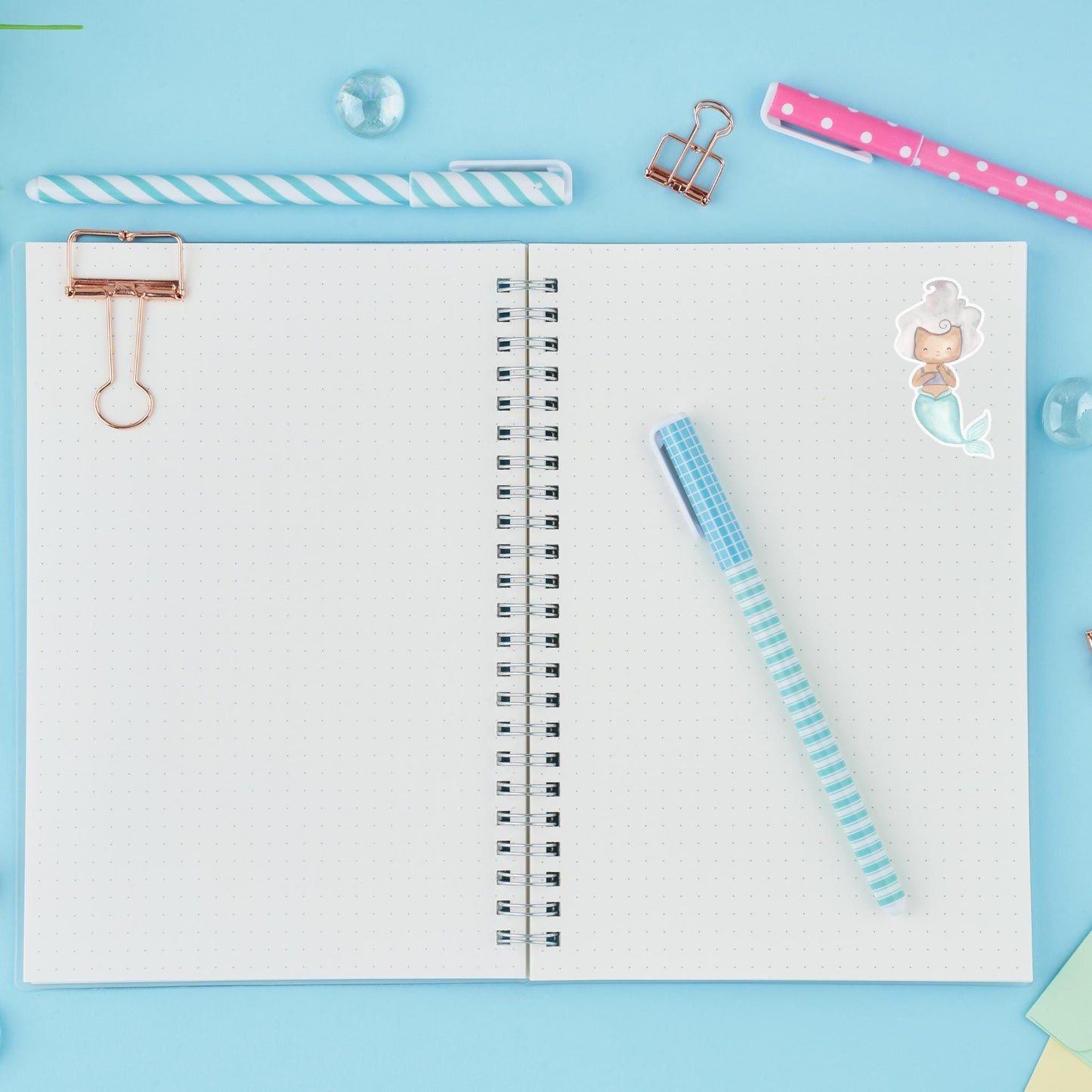 Notebook mit pinkem Stift und Meerjungfrau-Sticker aus Vinyl, ideal für Bullet Journals oder als dekorativer Aufkleber.