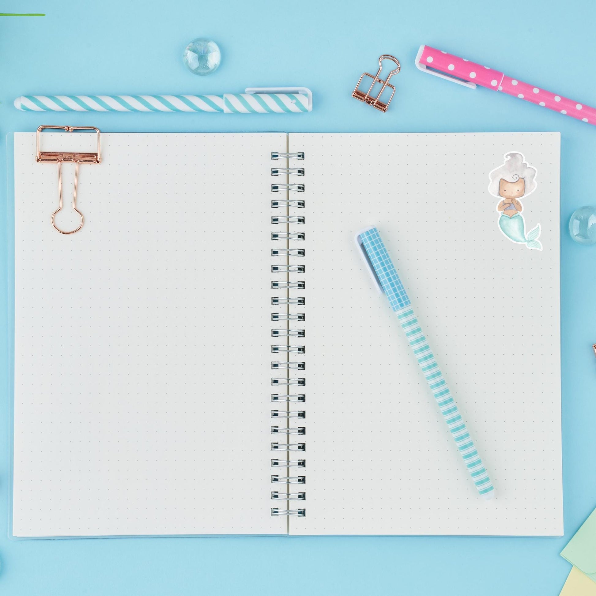 Notebook mit pinkem Stift und Meerjungfrau-Sticker aus Vinyl, ideal für Bullet Journals oder als dekorativer Aufkleber.