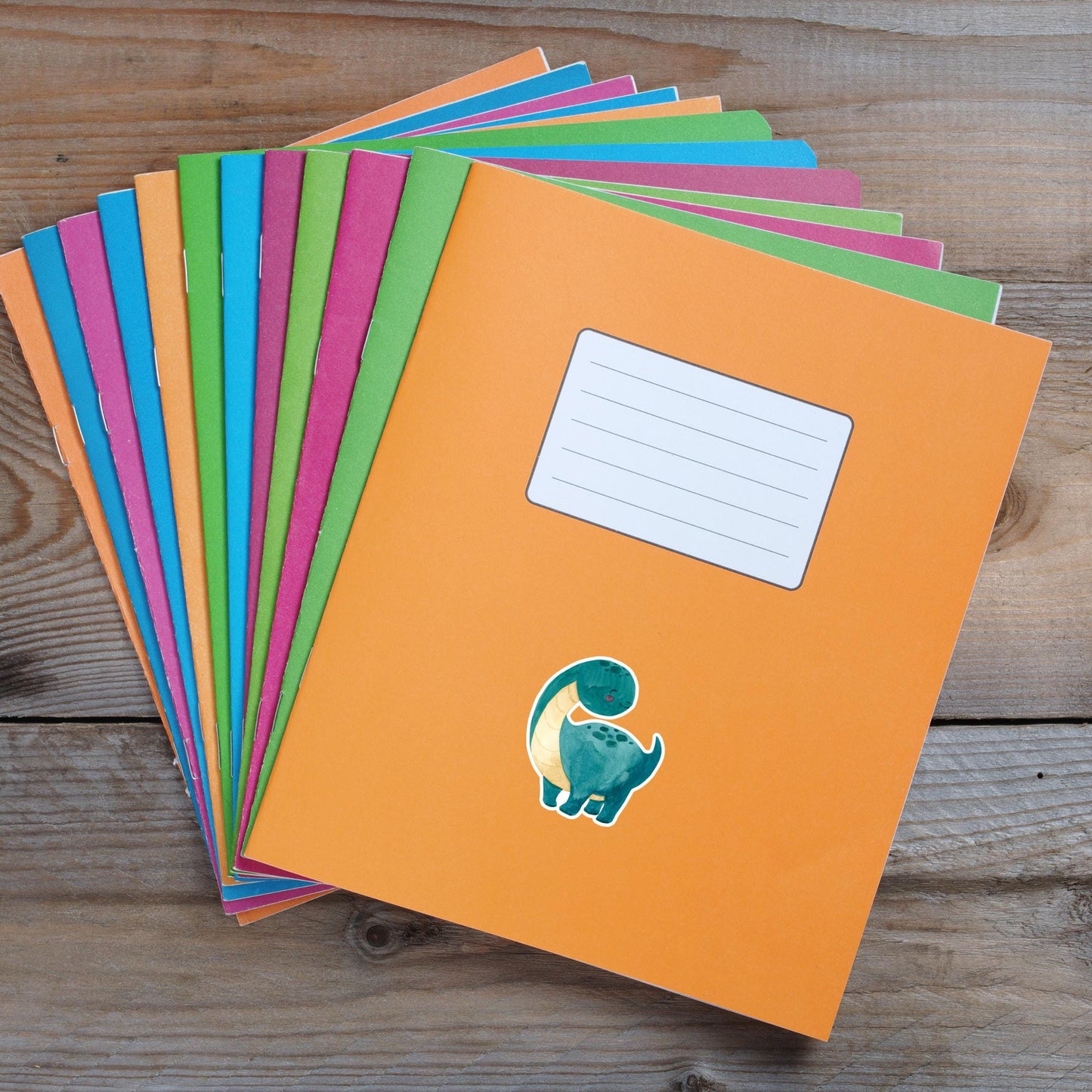 Sticker Dinosaurier dunkelgrün: Handgemalter Dino-Vinyl-Sticker auf einem bunten Notizbuchstapel, ideal für Bullet Journals und individuelle Dekorationen. Spritzfest und langlebig.