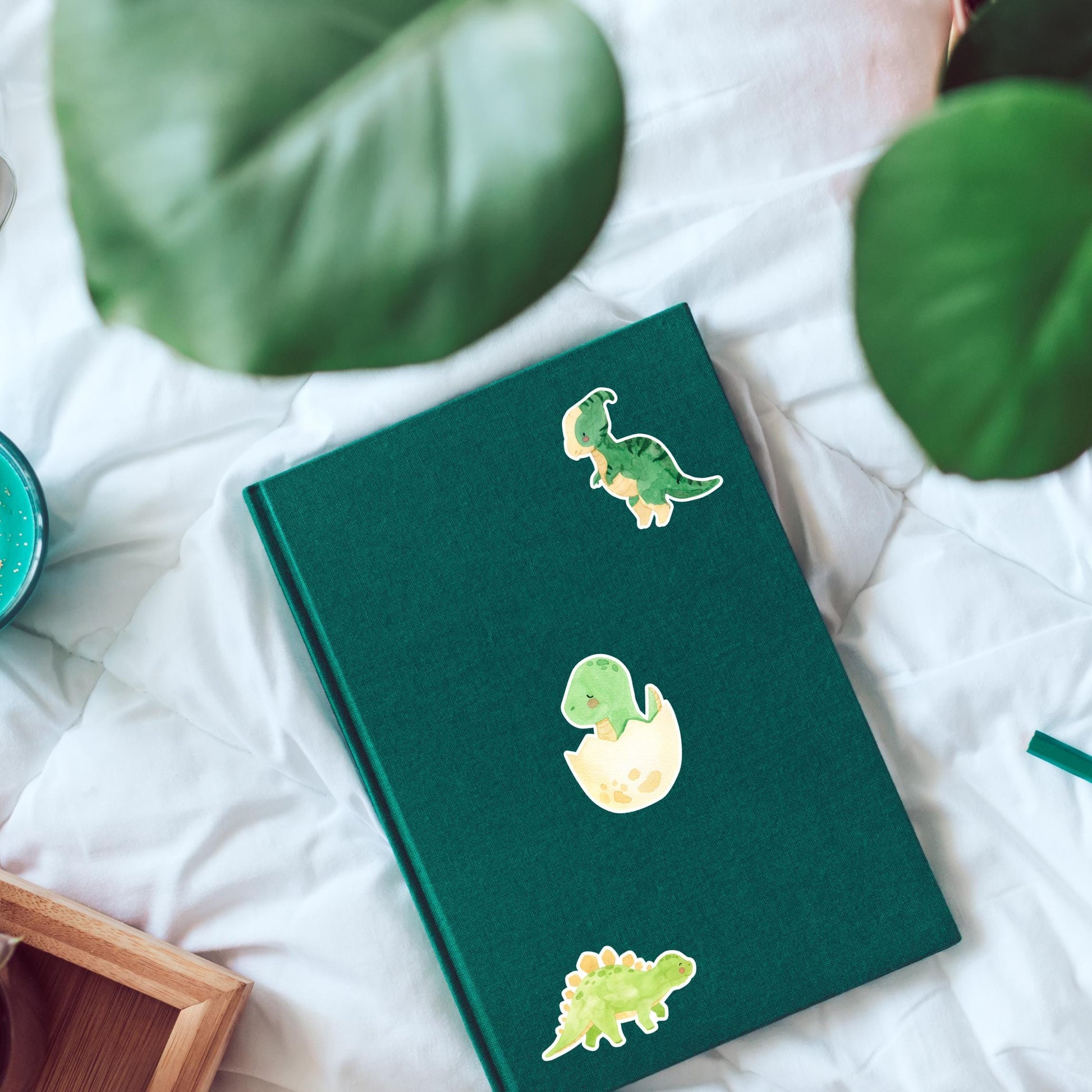 Sticker Dinosaurier im Ei: Grünes Buch mit handgemaltem Dino-Sticker, ideal für Bullet Journals oder Bastelprojekte. Hochwertiges Vinyl, langlebig und spritzfest.