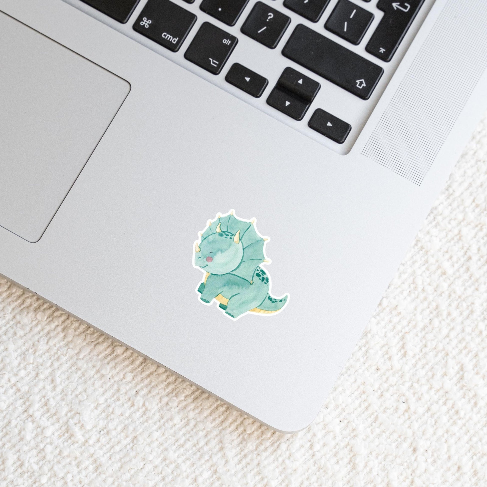 Sticker Dinosaurier Dreizack auf Laptop, zeigt handgemalten Dinosaurier. Hochwertiger Vinyl-Aufkleber für individuelle Dekoration. Ideal für Laptops, Journals und Bastelarbeiten.
