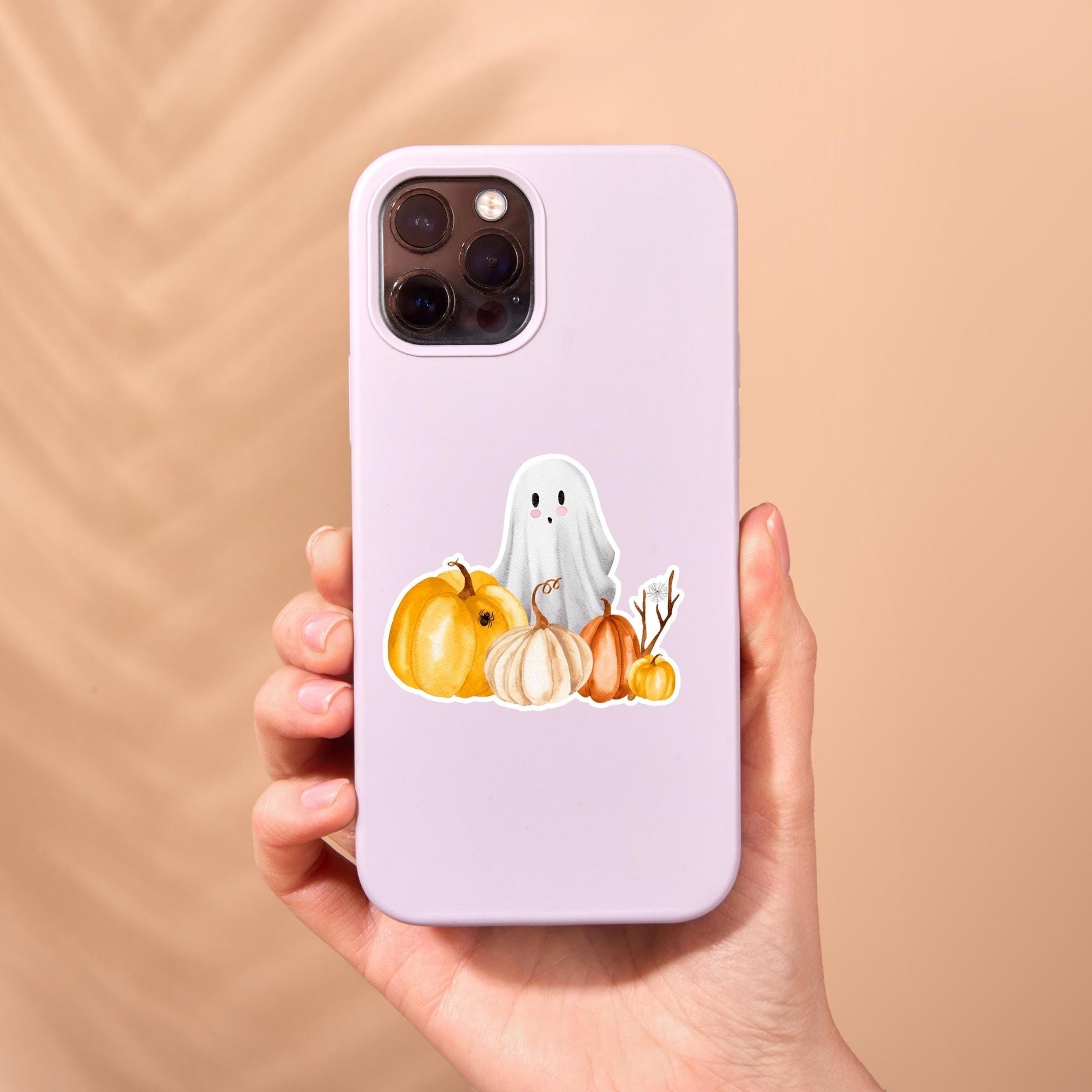 Hand hält Smartphone-Hülle mit Sticker Halloween: Gespenst und Kürbisse, ideal für Halloween-Liebhaber. Perfekt zum Verzieren von Bullet Journals oder Handyhüllen.