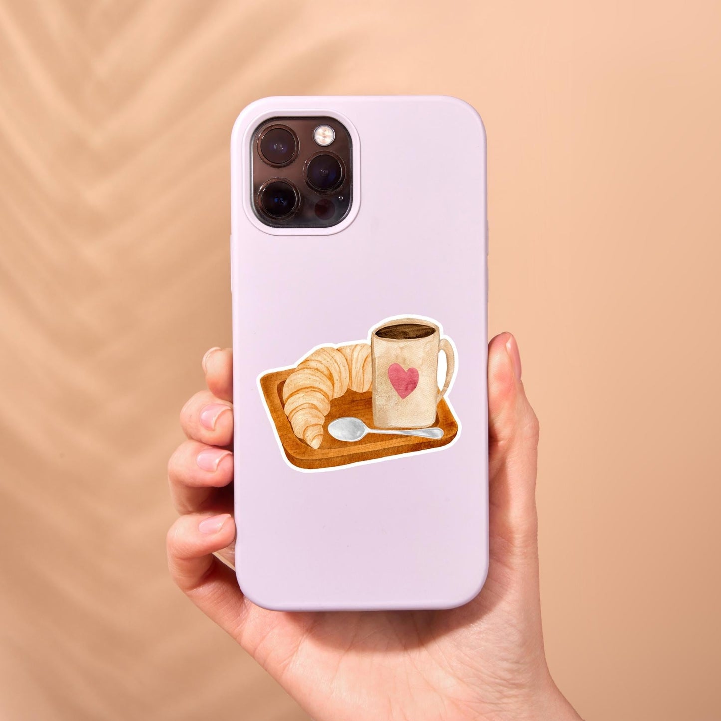 Hand hält Handyhülle mit Sticker Frühstück: Kaffee- und Croissant-Aufkleber, inspiriert zu gemütlichem Frühstück, auf hochwertigem Vinyl, nicht spülmaschinenfest, ideal für individuelle Looks.