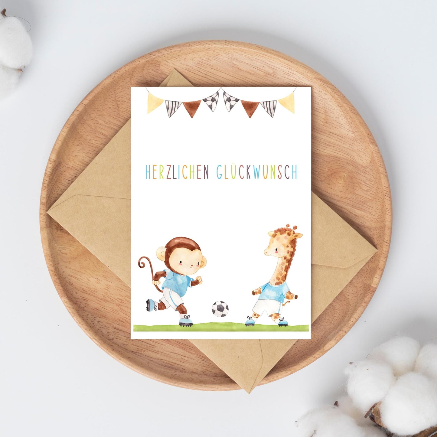 Karte Kindergeburtstag Fußball A6 zeigt handgemalte Cartoon-Motive von Affe und Giraffe beim Fußballspiel, mit 'Herzlichen Glückwunsch' Schriftzug auf hochwertigem Naturpapier.