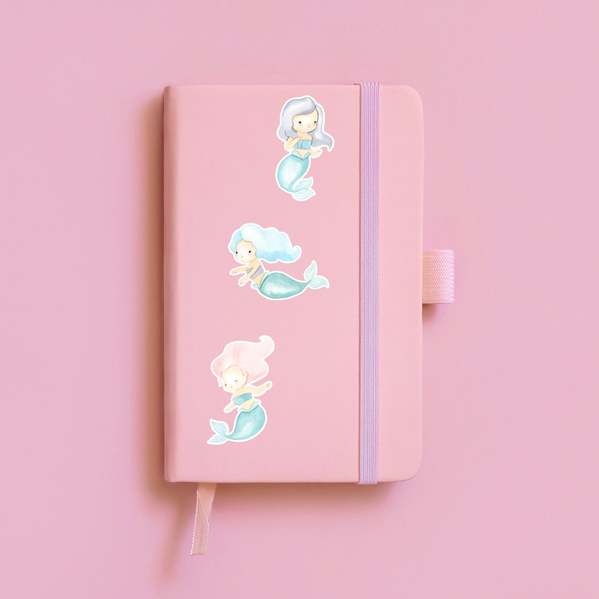 Sticker Meerjungfrau blau: Pinkes Notizbuch mit handgemalten Meerjungfrau-Stickern aus Vinyl, ideal für Bullet Journals oder Schulhefte. Spritzfest und langlebig.