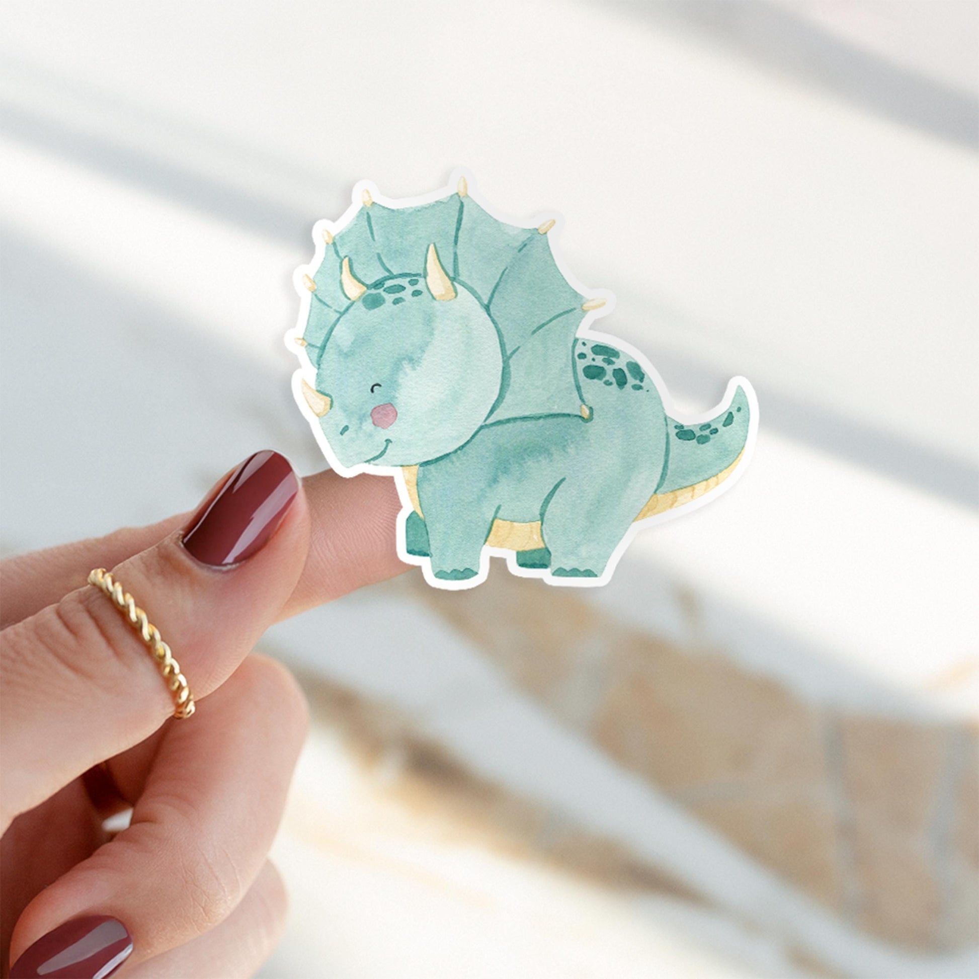 Person hält Sticker Dinosaurier Dreizack, handgemalter Dino aus hochwertigem Vinyl, ideal für Bullet Journals und Handys. Perfekt als individuelles Accessoire oder Geschenk.