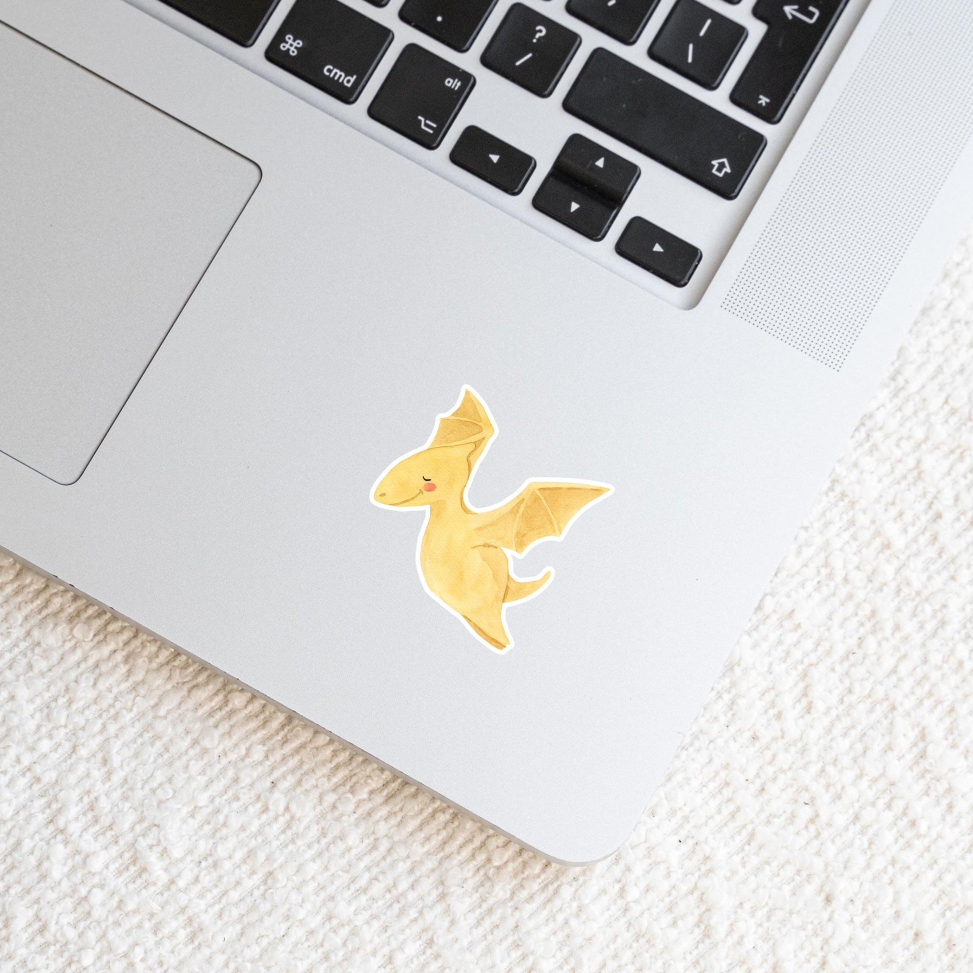 Laptop mit Sticker Dinosaurier fliegt, zeigt handgemalten Dino-Aufkleber, ideal für individuelle Gestaltung. Hochwertiges, langlebiges Vinyl, perfekt für Laptops und Journals.