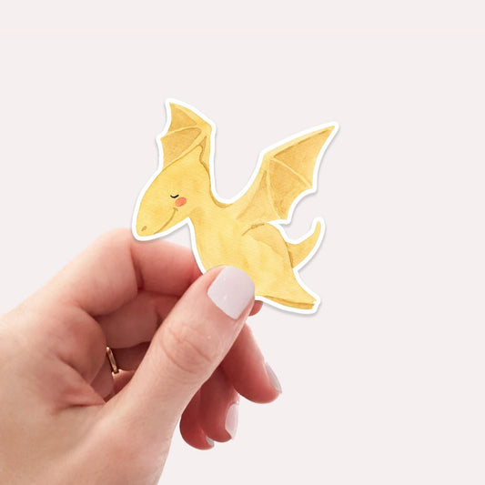 Hand hält den handgemalten Sticker Dinosaurier fliegt, ideal für Bullet Journale oder Handys geeignet. Hochwertiges, spritzfestes Vinyl, ca. 6x5 cm groß.