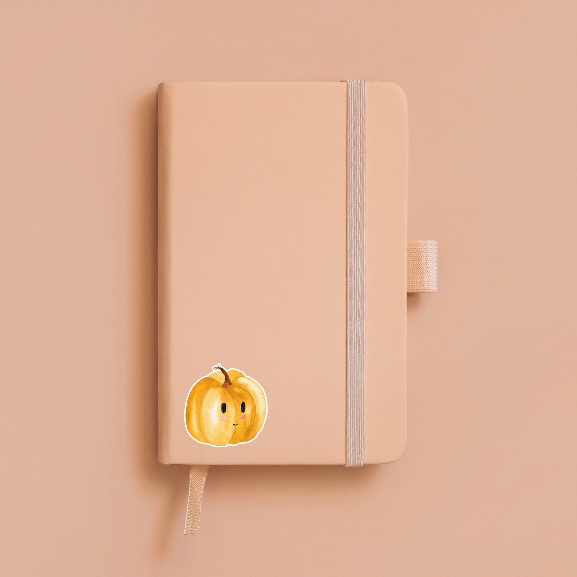 Sticker Kürbis auf einem Notizbuch, handgemalter Vinyl-Aufkleber, ideal für Bullet Journals oder Laptops, langlebig und spritzfest, perfekt für Herbstliebhaber.