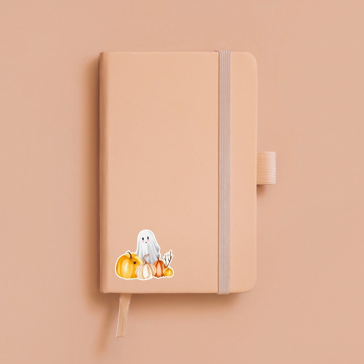 Halloween-Sticker mit handgemaltem Gespenst und Kürbissen auf einem Notizbuch, ideal zur individuellen Gestaltung von Bullet Journals oder als kreatives Bastelaccessoire.