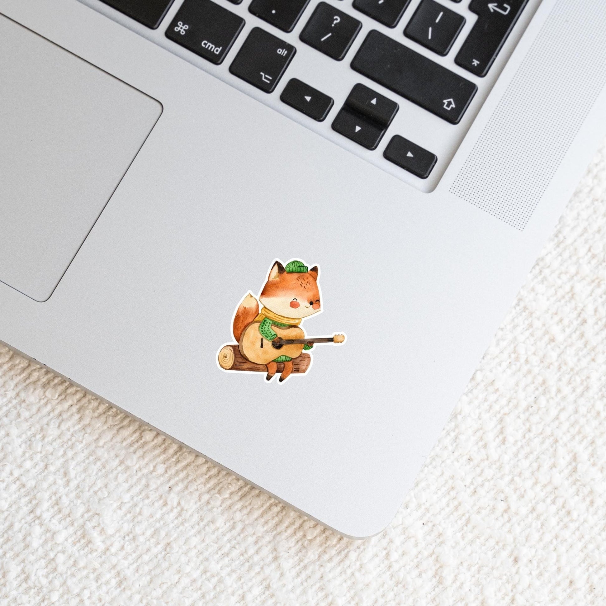 Sticker Fuchs & Gitarre auf Laptop; ein handgemalter Vinyl-Aufkleber eines Fuchses mit Gitarre, ideal zur Personalisierung von Laptops oder Notizbüchern.