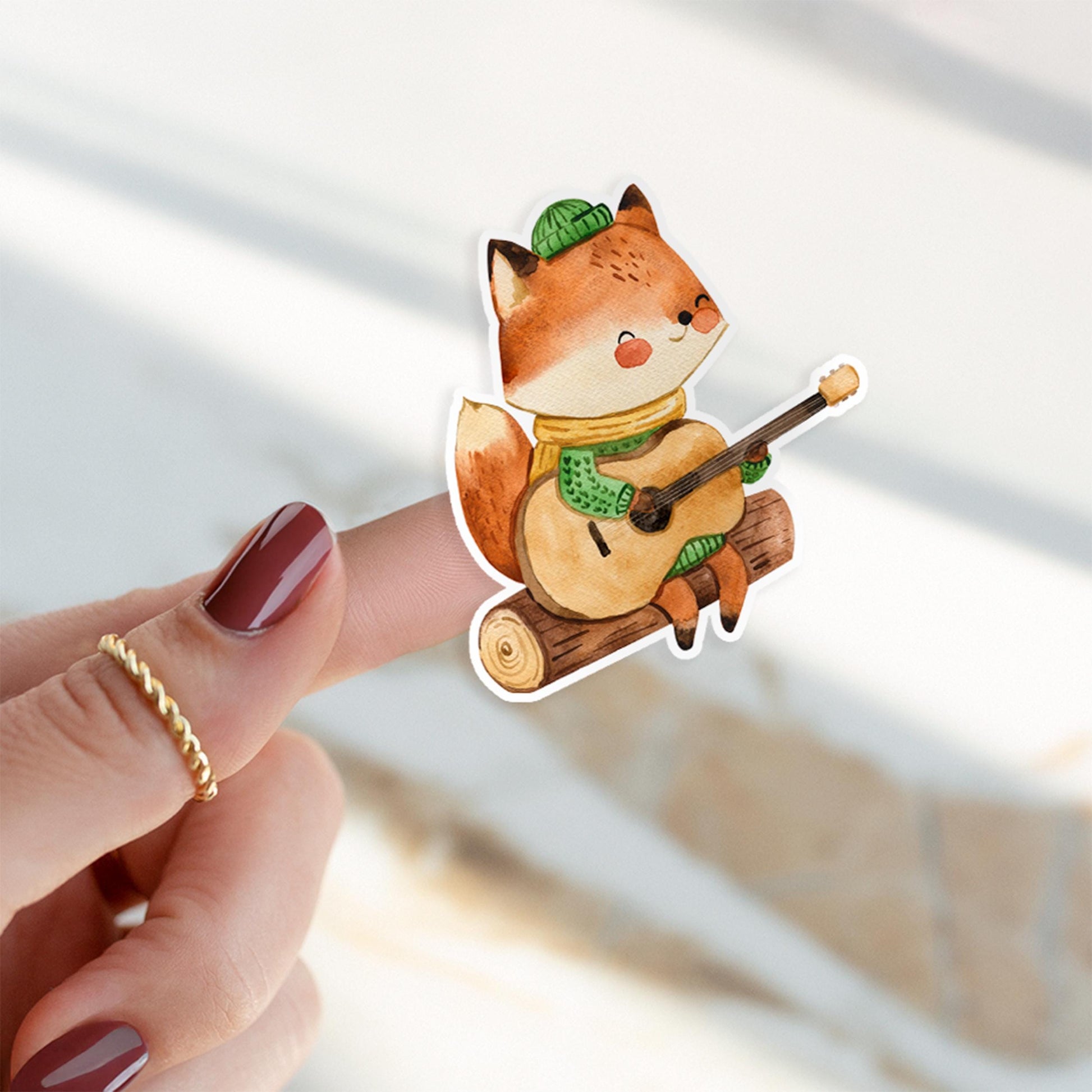 Sticker Fuchs & Gitarre: Nahaufnahme eines handgemalten Vinyl-Stickers zeigt einen Fuchs, der Gitarre spielt, von einer Hand gehalten. Ideal für kreative Dekorationen.