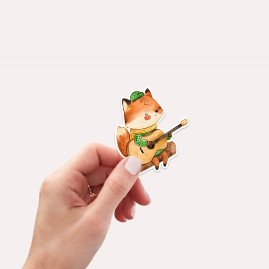 Hand hält Sticker Fuchs & Gitarre: Handgemalter, langlebiger Vinyl-Aufkleber, ideal zum Dekorieren von Laptops, Bullet Journals und mehr. Perfekt für Musikliebhaber.