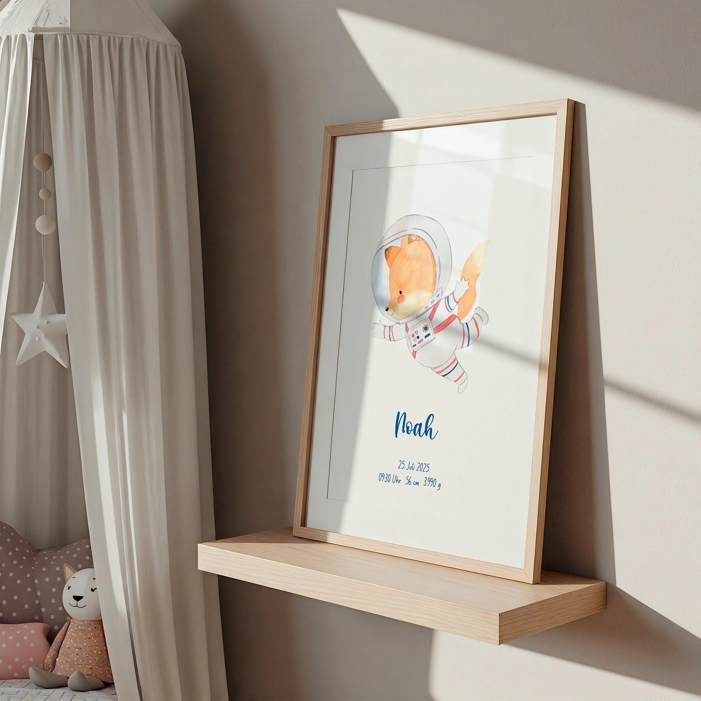 Geburtsposter Astronaut personalisiert mit Fuchs in Astronautenanzug, Name Noah und Geburtsdaten, auf Holzregal in Kinderzimmer-Ecke mit Stoffhimmel und Kuscheltieren.