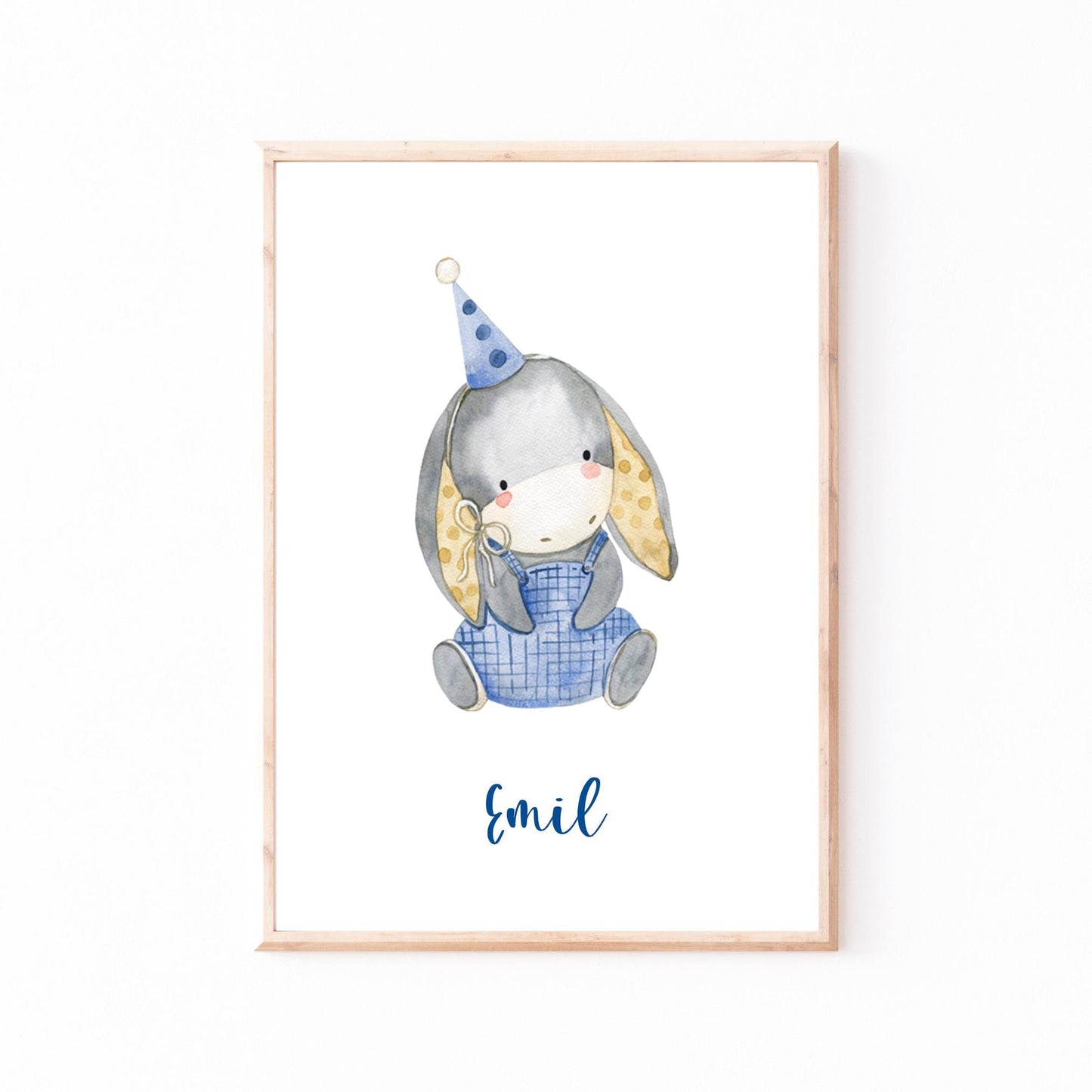 Geburtsposter Esel personalisiert: Aquarell-Illustration eines grauen Hasen in blauer Latzhose mit Partyhut, darunter steht „Emil“. Ideal für Kinderzimmerdekoration.