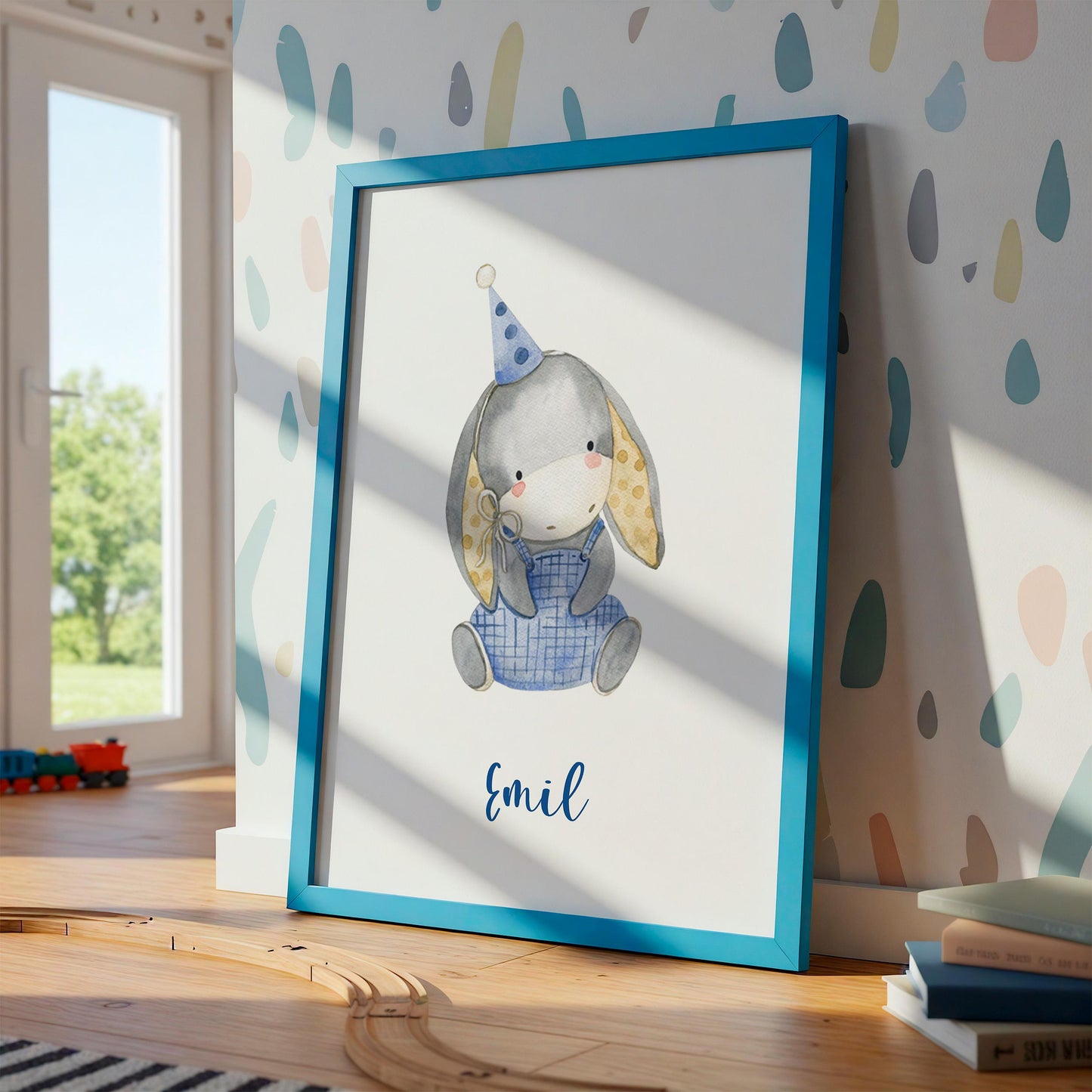 Geburtsposter Esel personalisiert: Aquarell-Hase im blauen Rahmen, mit Namen Emil, Spielzeugzug, Bücher, und natürlichem Licht im Kinderzimmer.