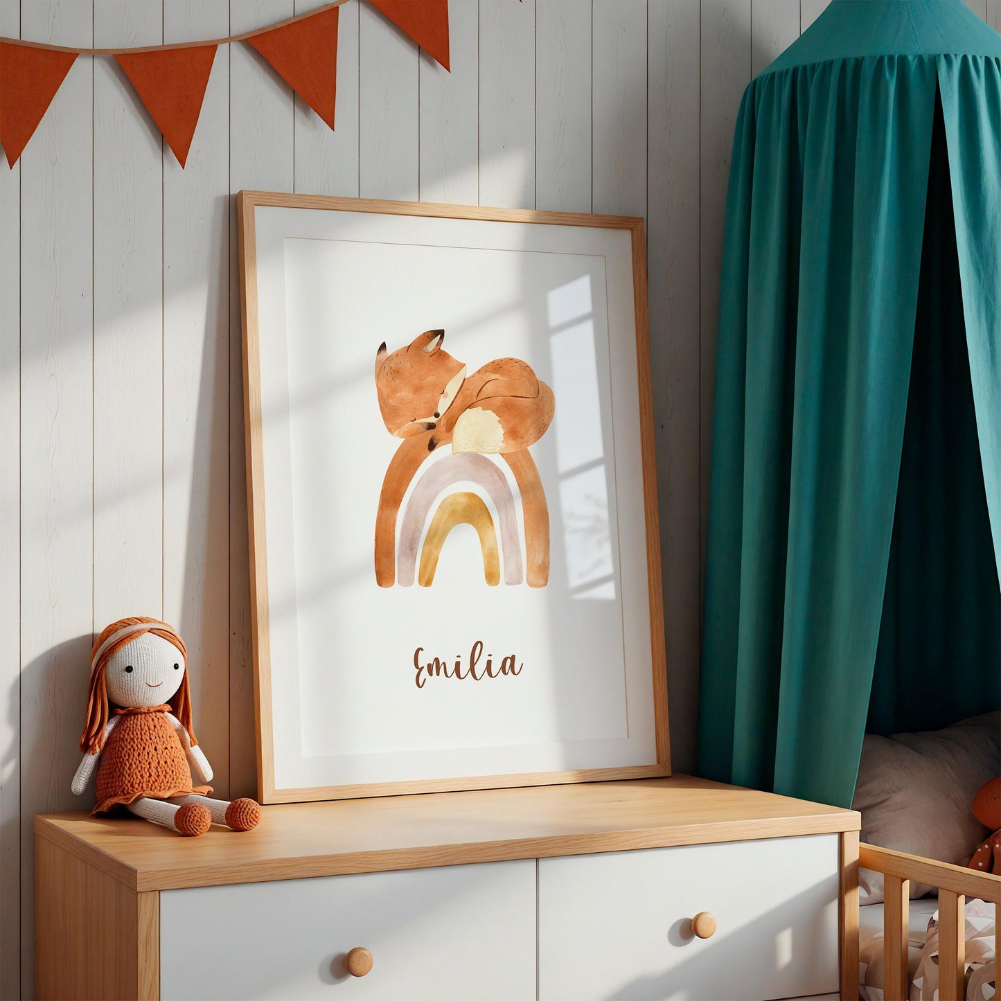 Geburtsposter Fuchs auf Regenbogen personalisiert: Ein gerahmtes Poster mit schlafendem Fuchs auf Regenbogen, darunter der Name Emilia, auf einer Kommode im Kinderzimmer.