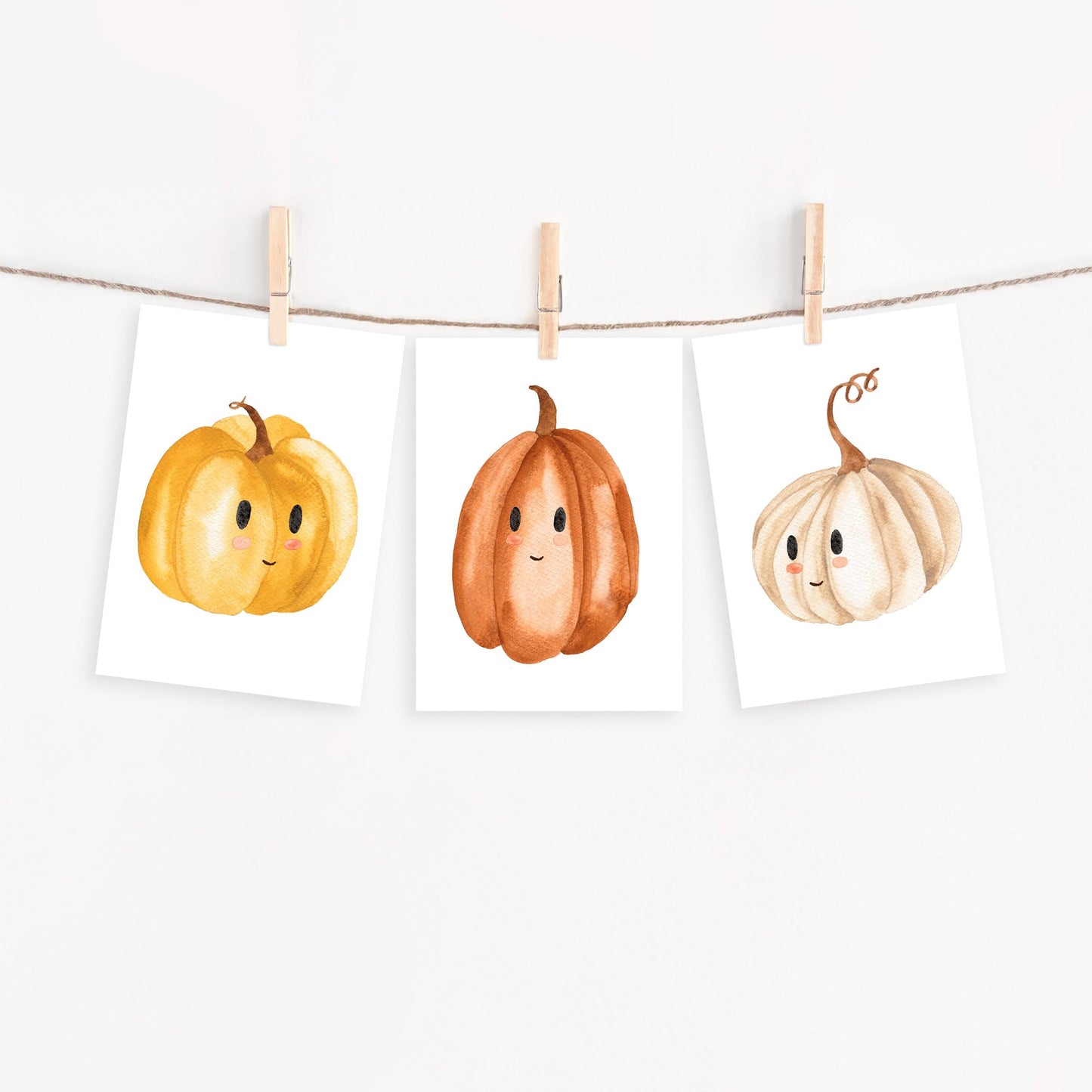 Postkarten Set Kürbis A6: Drei minimalistische, lächelnde Kürbis-Illustrationen an Kordel, ideal für herbstliche Grüße oder Deko. Gedruckt auf hochwertigem, mattem Naturpapier.