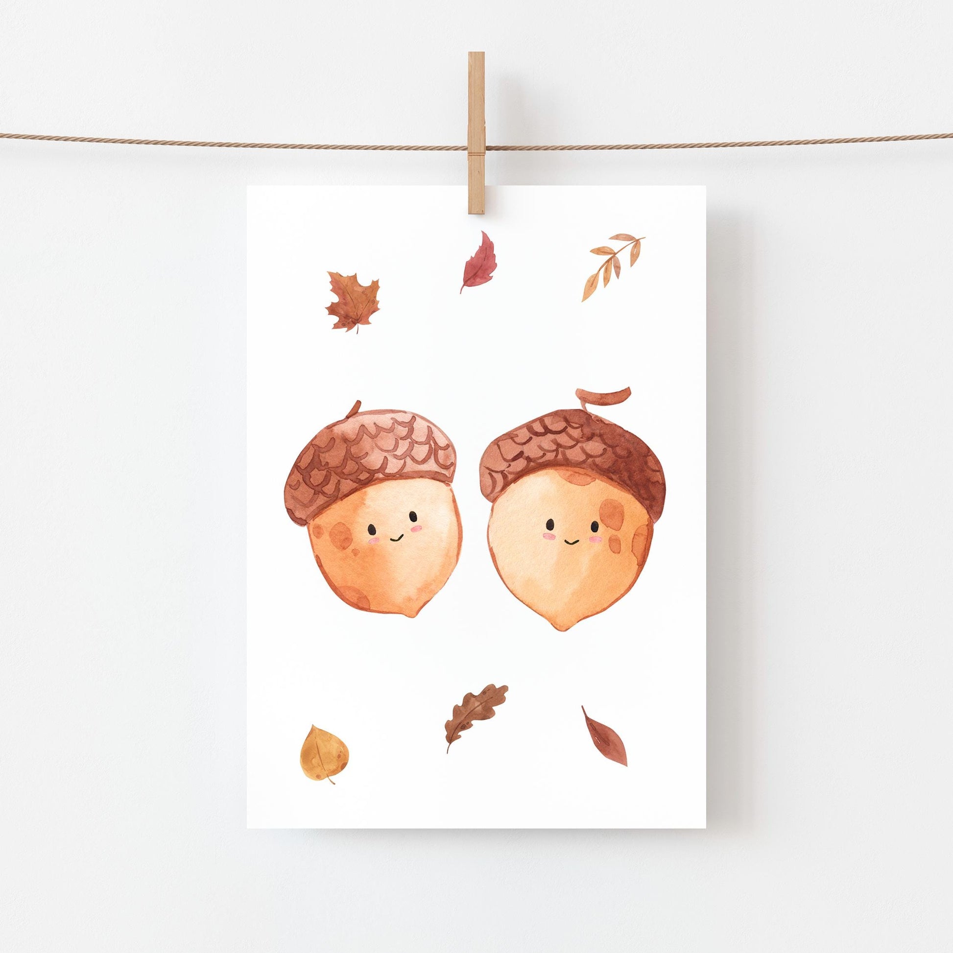 Karte Eicheln & Herbstlaub A6 zeigt zwei lächelnde Eicheln mit Herbstblättern, gedruckt auf hochwertigem, mattem Naturpapier, ideal für Grüße oder Herbstdekoration.