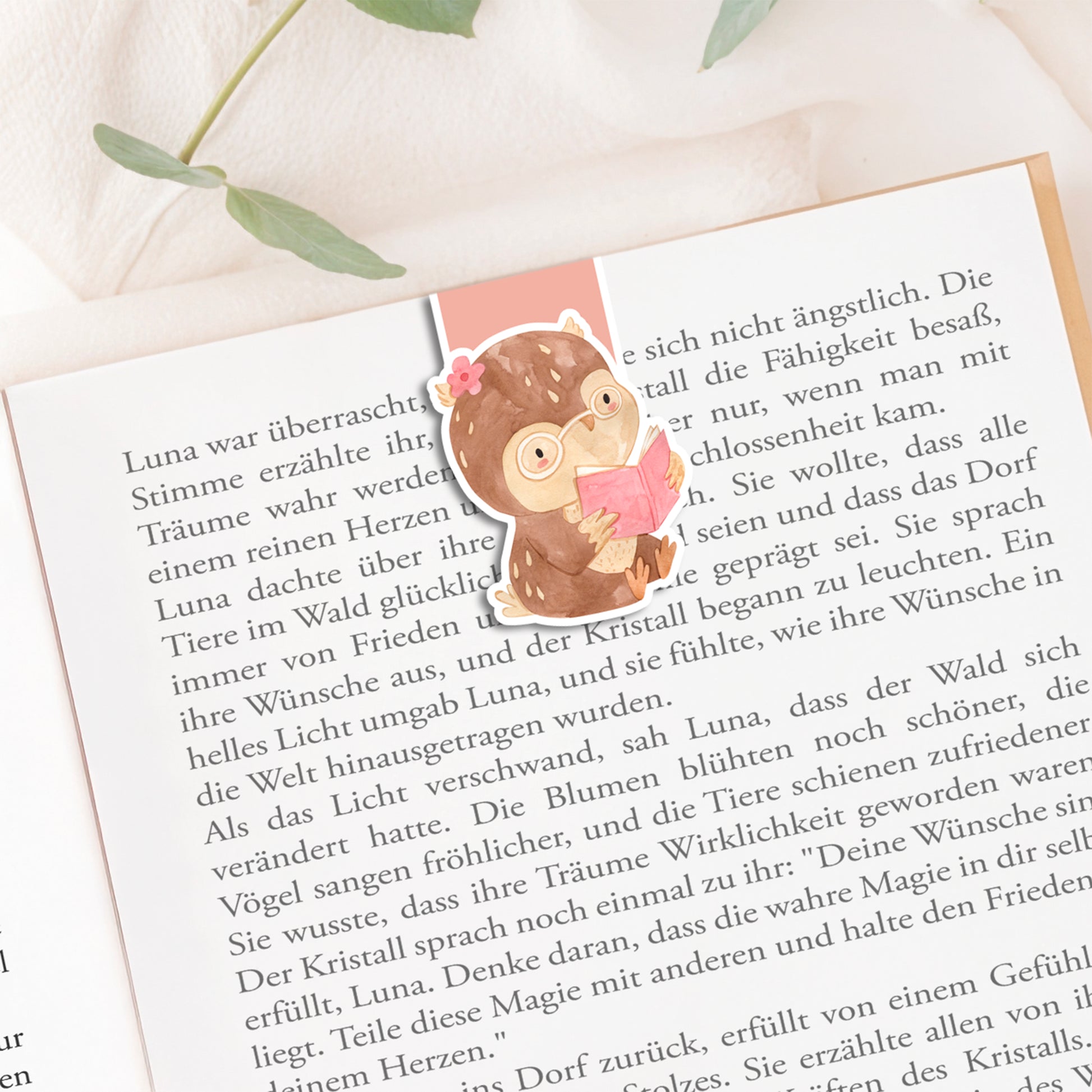 Magnetisches Lesezeichen Eule mit handgemaltem Eulenmotiv, auf Buchseite platziert. Ideal für Buchliebhaberinnen, aus hochwertigem Papier mit Vinylschutz, langlebig und praktisch.