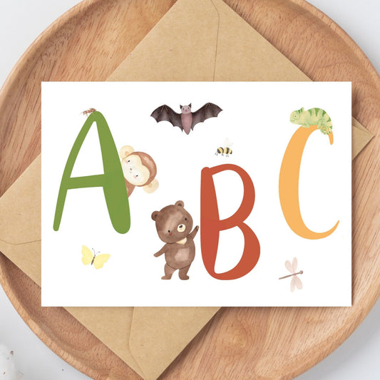 Karte ABC A6 mit bunten Buchstaben und Tieren auf einer Holzplatte, perfekt als Geschenk zum Schulanfang, gedruckt auf hochwertigem, mattem 300g Naturpapier.
