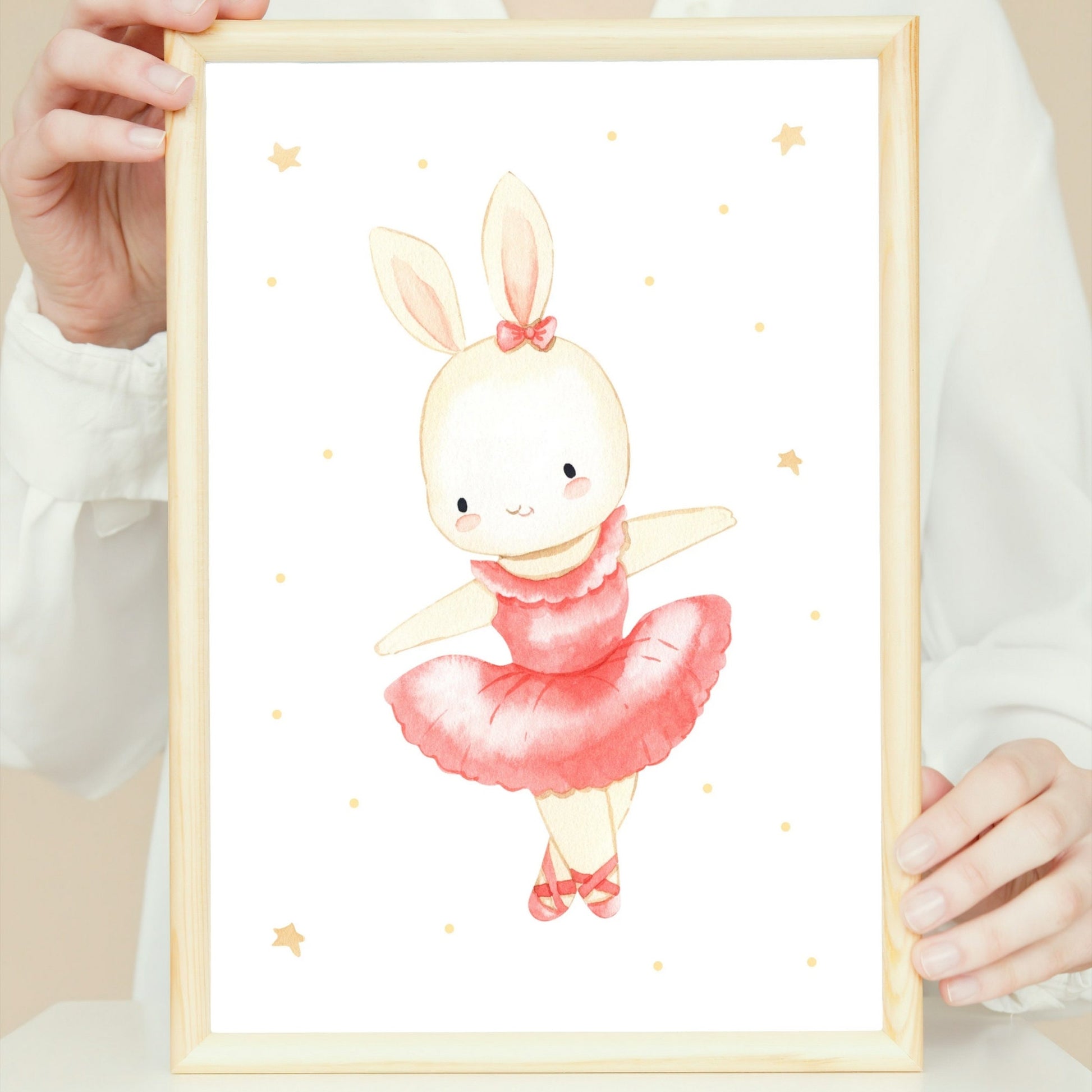 Person hält ein Poster mit einer detaillierten Zeichnung eines Ballerinahasen in einem rosa Kleid, erhältlich in A4 und A3 auf hochwertigem Naturpapier.