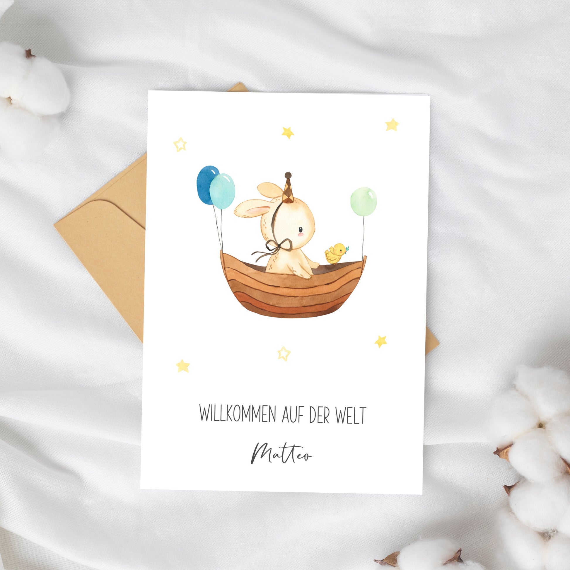 Personalisierte Geburtskarte Hase & Luftschiff A6 mit Aquarellhase im Boot, Luftballons und Sternen. Inklusive Willkommen auf der Welt und Namen Matteo.