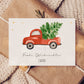 Personalisierte Weihnachtskarte Auto & Baum A6 auf Geschenk, zeigt Aquarell eines roten Trucks mit Tannenbaum, umgeben von goldenen Sternen und Frohe Weihnachten Text.