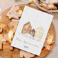 Personalisierte Weihnachtskarte Häuser A6 mit Schneehäusern und Frohe Weihnachten für Anton, neben Lebkuchen auf Holzbrett, ideal für festliche Grüße.