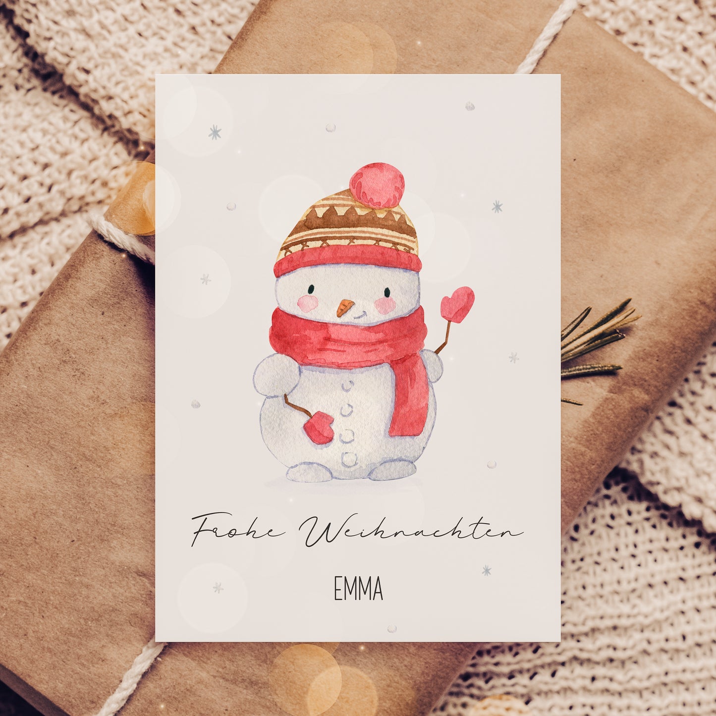 Weihnachtskarte mit Schneemann, personalisiert mit Namen Emma, auf Geschenk und Strickdecke. Perfekt für Kinder, Familiengrüße oder als Geschenkbeilage.