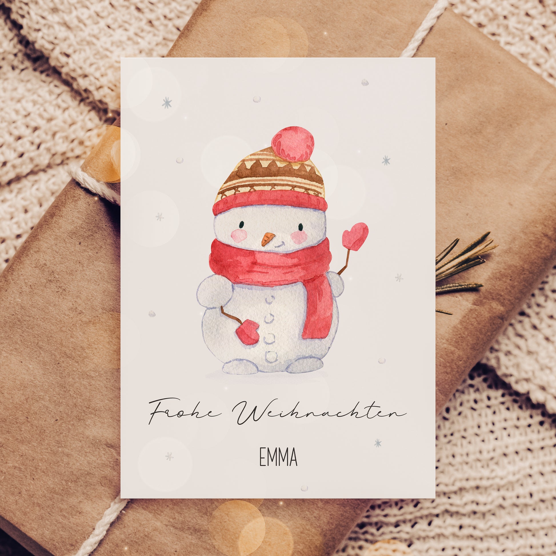 Weihnachtskarte mit Schneemann, personalisiert mit Namen Emma, auf Geschenk und Strickdecke. Perfekt für Kinder, Familiengrüße oder als Geschenkbeilage.