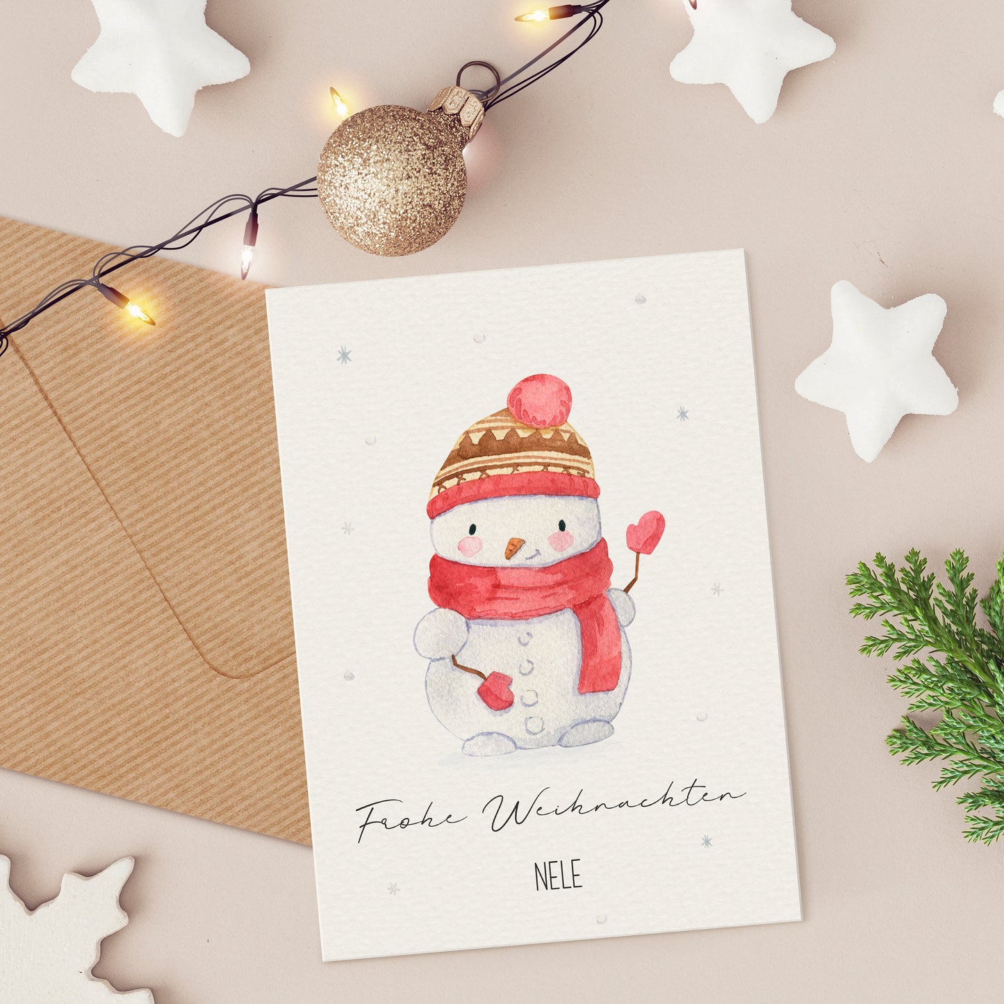 Personalisierte Weihnachtskarte Schneemann A6 mit handgemaltem Schneemann, roten Akzenten und Frohe Weihnachten Schriftzug, umgeben von festlichen Dekorationen wie Sternen und Lichtern.