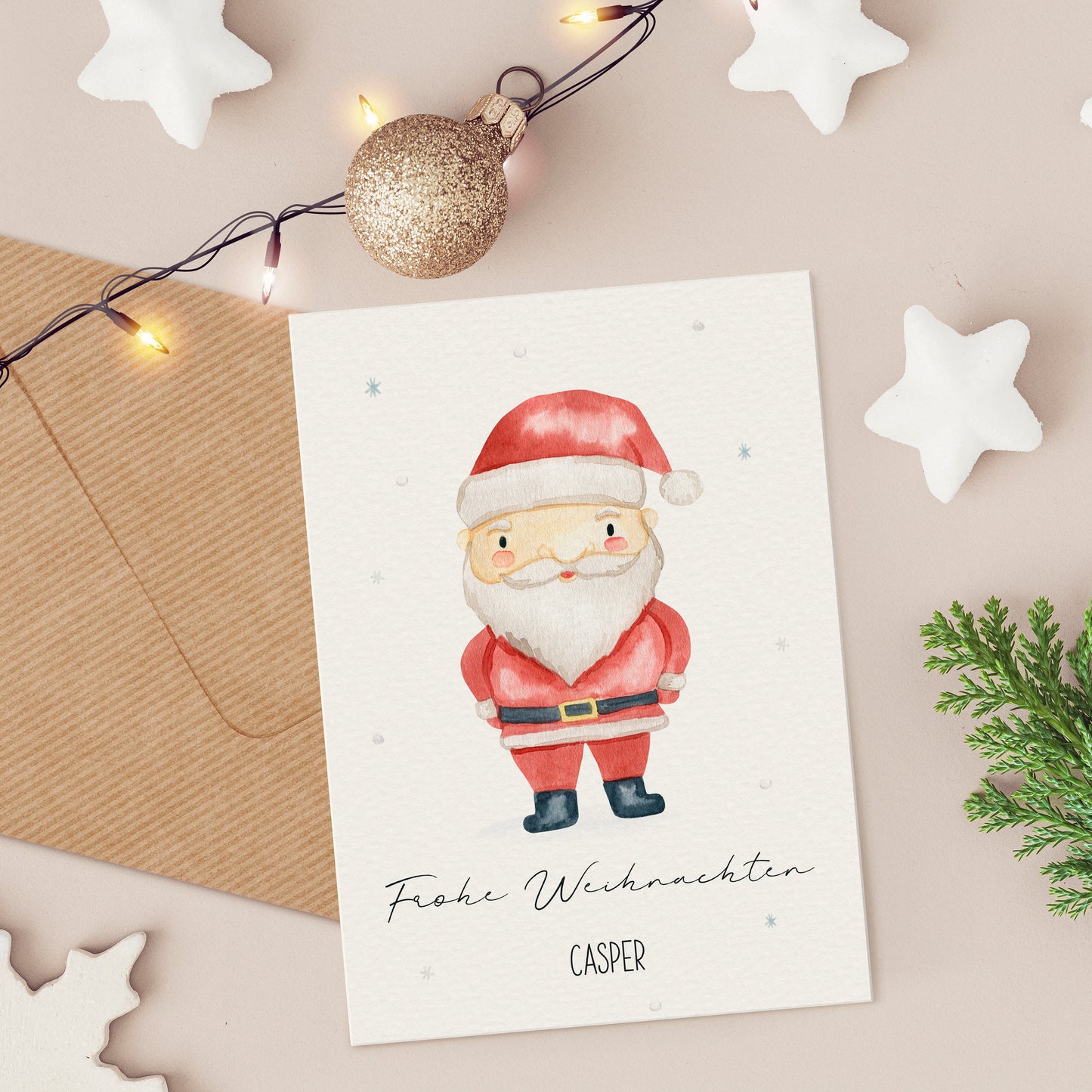 Personalisierte Weihnachtskarte Weihnachtsmann A6 mit handgemaltem Santa und Frohe Weihnachten Aufschrift, auf einem Tisch mit festlichen Dekorationen arrangiert.