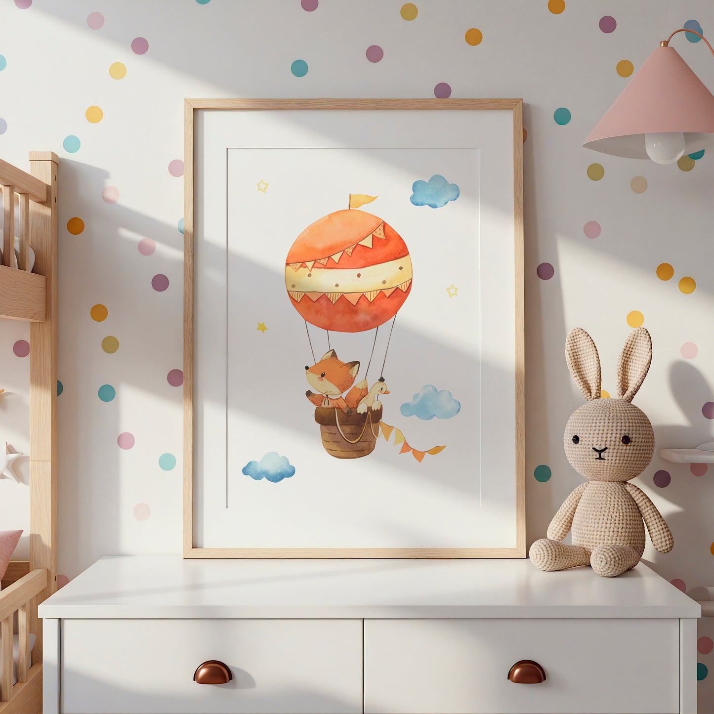 Posterset Himmelsstürmer Elefant, Hase und Fuchs A4 & A3 auf weißer Kommode mit gestricktem Hasen, pastellfarbenen Punkten und rosa Lampe im Kinderzimmer.