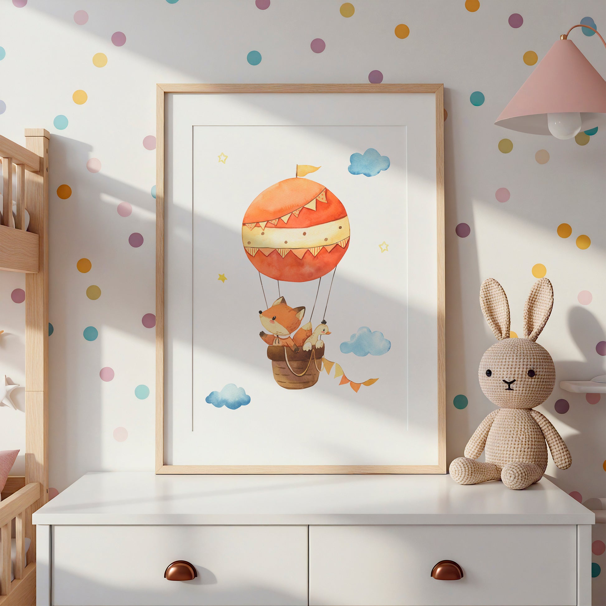 Posterset Himmelsstürmer Elefant, Hase und Fuchs A4 & A3 auf weißer Kommode mit gestricktem Hasen, pastellfarbenen Punkten und rosa Lampe im Kinderzimmer.