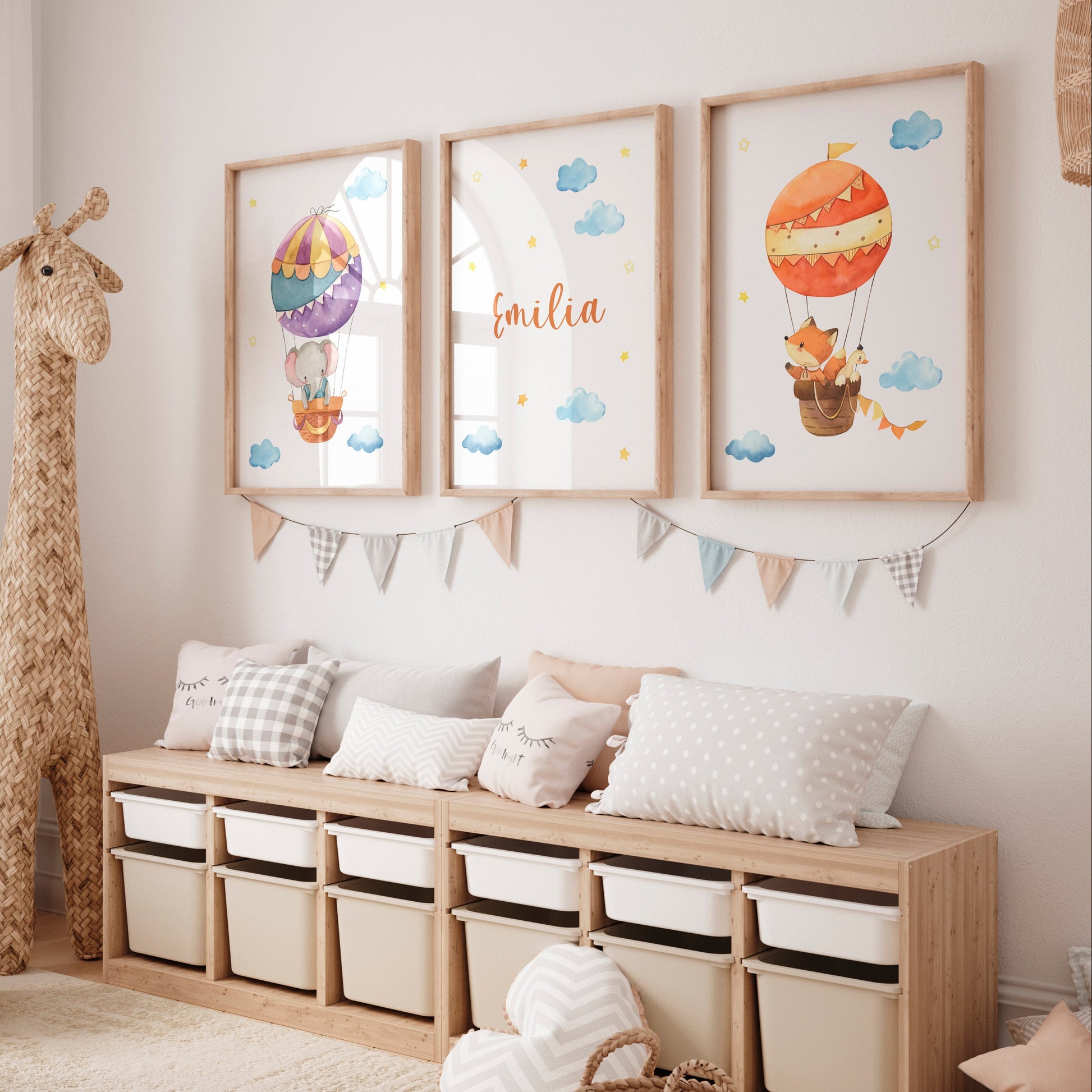 Personalisierte Namensposter im 3er Set: Elefant und Fuchs im Heißluftballon, mittig mit Namen Emilia, unterstrichen durch pastellfarbene Deko im Kinderzimmer.