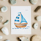 Postkarte Segelboot A6 zeigt ein Aquarell eines kleinen Segelboots mit zwei blauen Segeln auf stilisierten Wellen, umgeben von Steinen. Ideal für maritime Grüße.