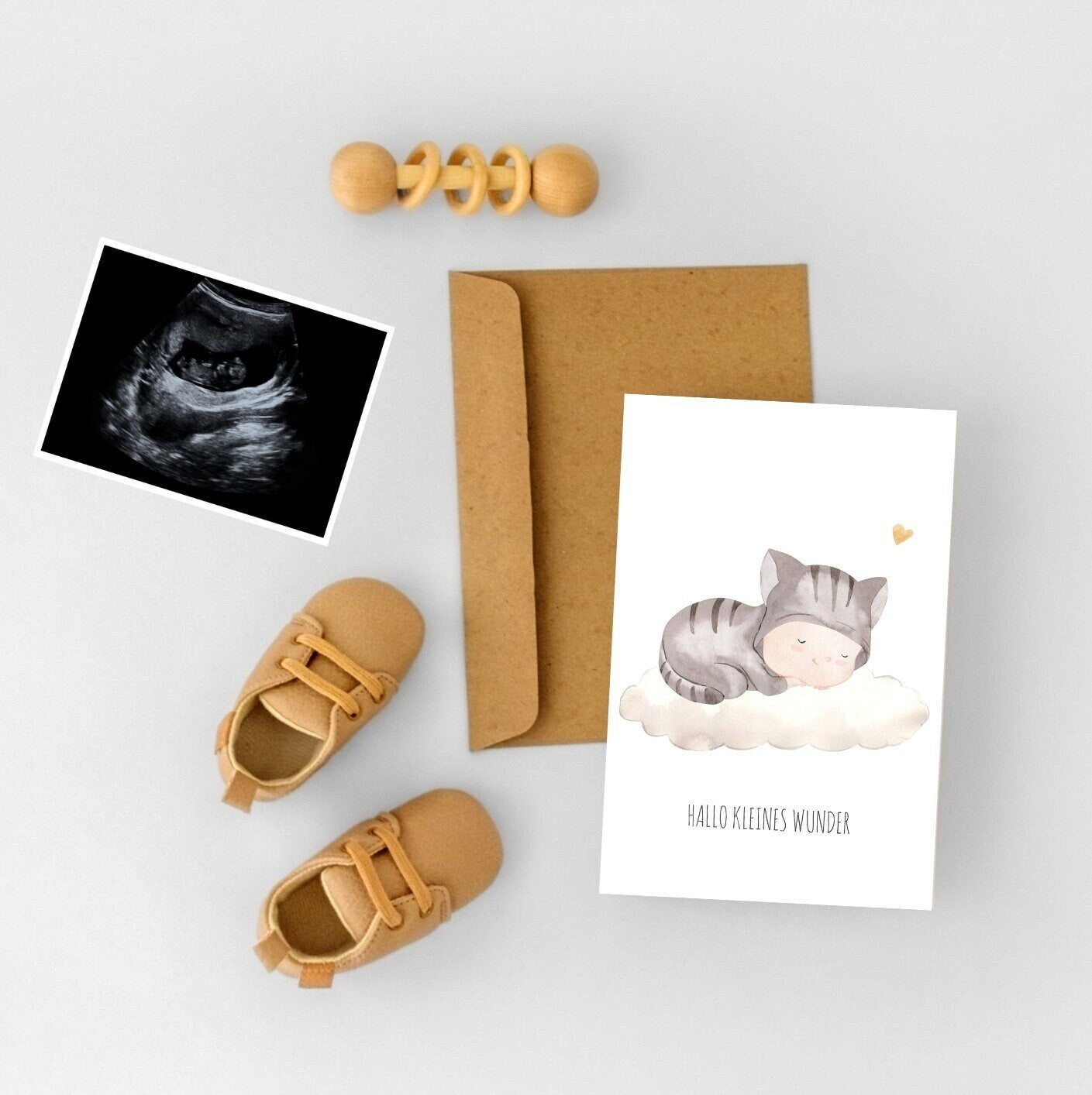 Karte Hallo kleines Wunder A6: Eine Postkarte mit Babymotiv, ein Paar Babyschuhe und ein Umschlag. Perfekt als Glückwunschkarte zur Geburt.