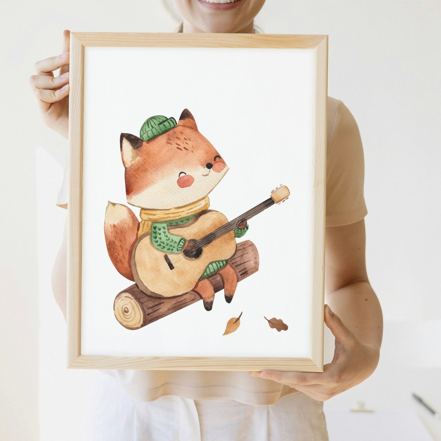 Posterset Camping Fuchs und Igel A4 & A3: Frau hält ein Poster mit einem Fuchs, der auf einem Baumstamm sitzt, perfekt für Kinderzimmerdeko.