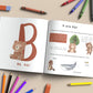 Alphabet Buch - ABC der Tiere aufgeschlagen mit Illustrationen von Bären, großem B und passendem Text und mehreren Buntstiften daneben.