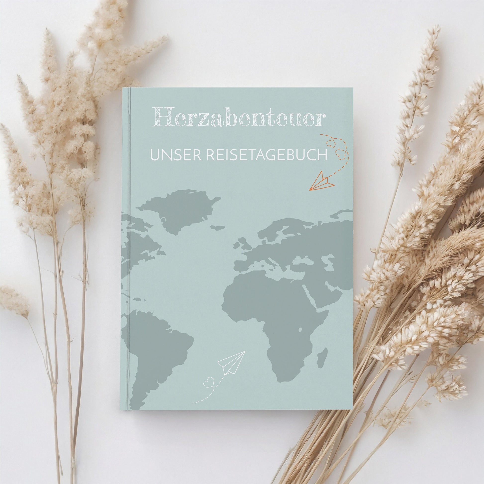 Reisetagebuch für Paare Herzabenteuer A5 Hardcover, Cover mit einer Weltkarte und Papierfliegern, ideal zum Planen und Festhalten von Reiseerinnerungen.